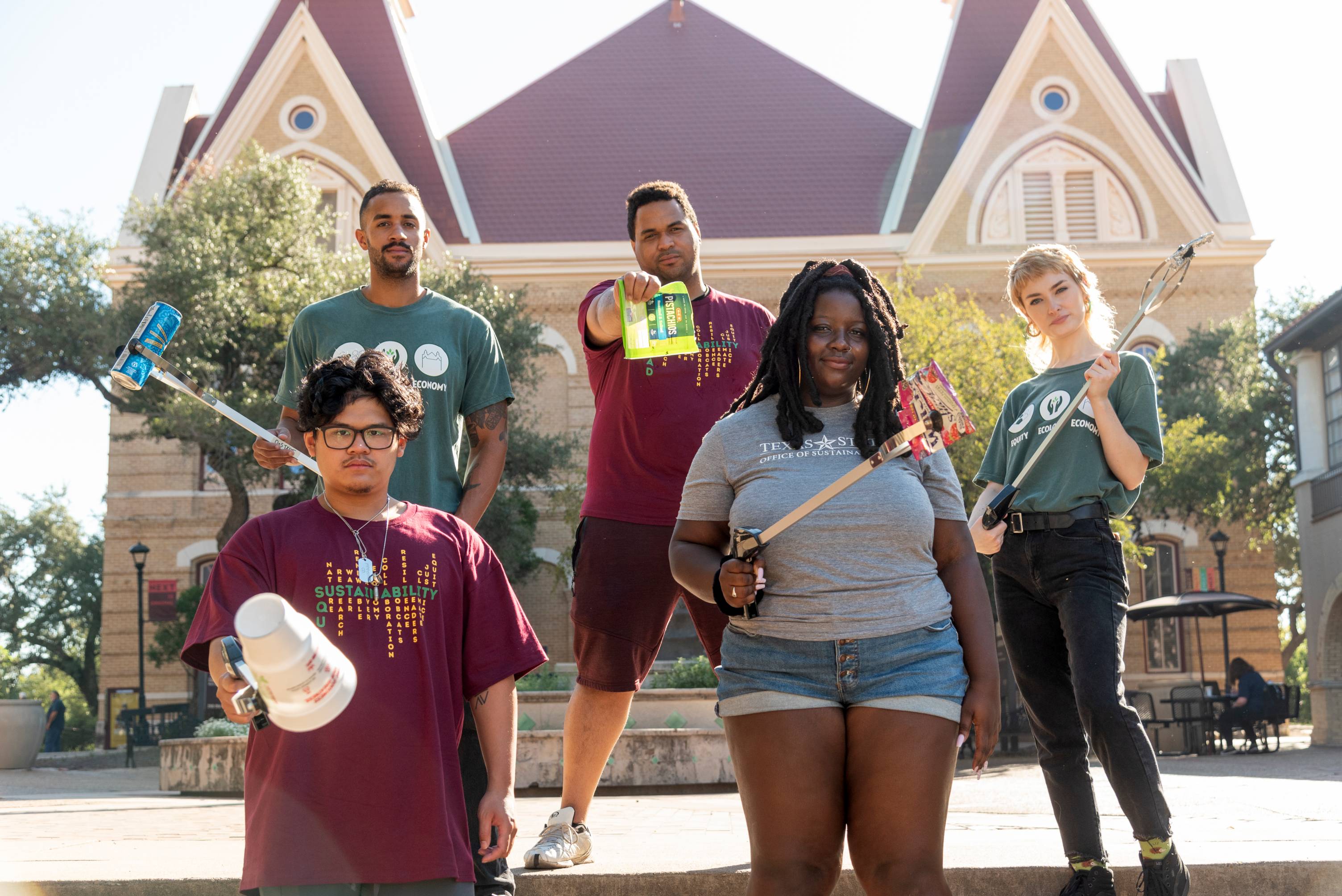 people posing with litter grabbers and litter in front of old main