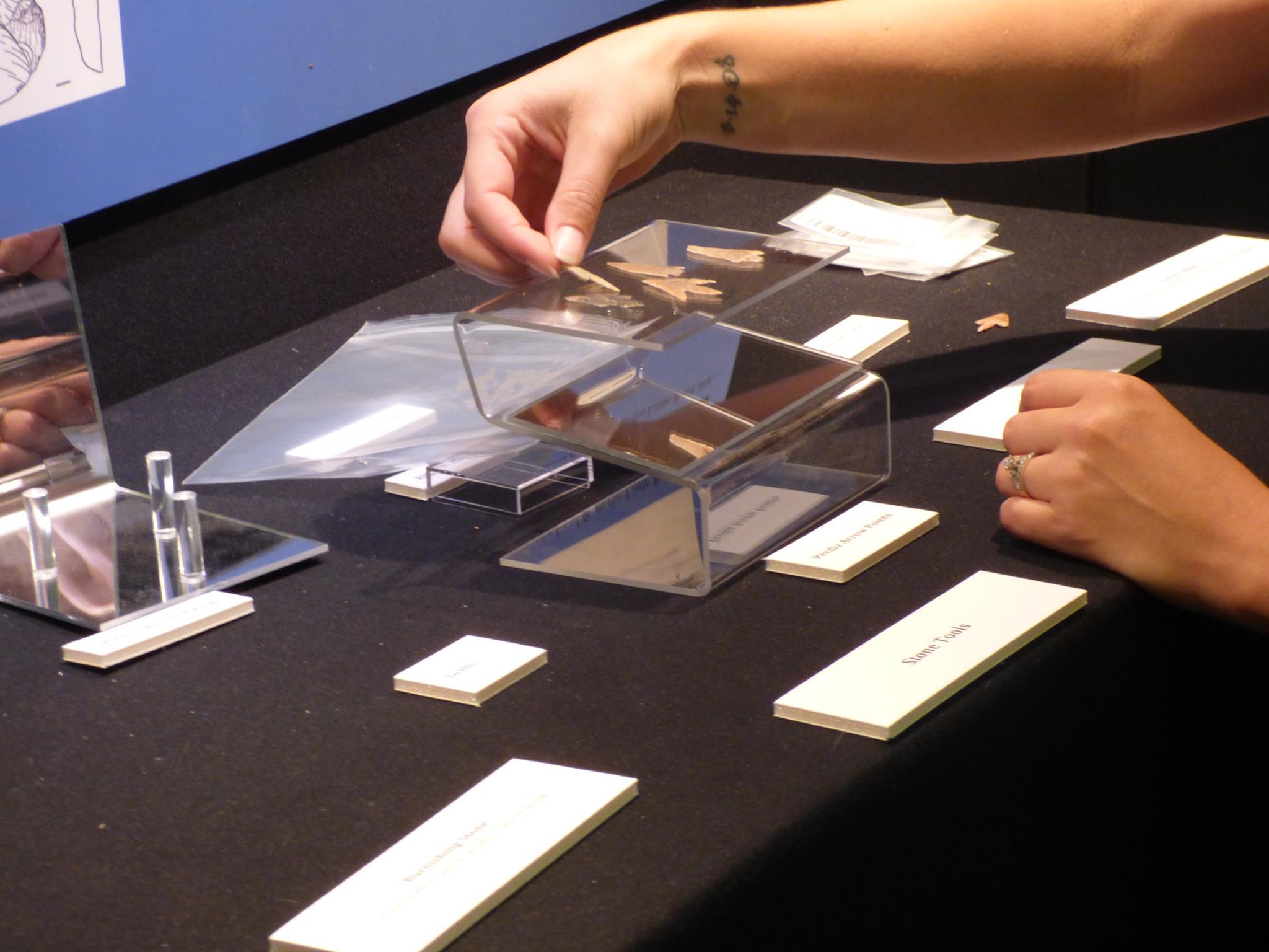 close up of an exhibit being assembled, with artifacts being placed on display risers