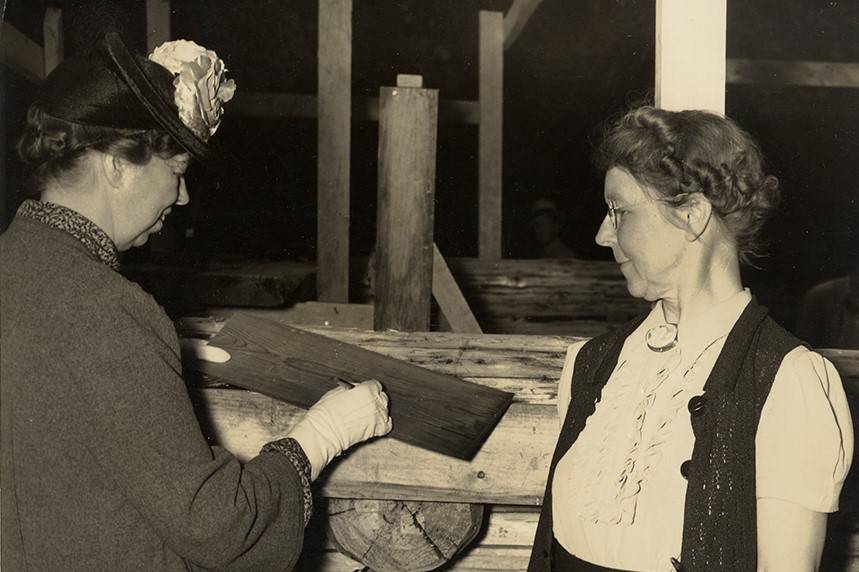 Ellen Quillin observes Eleanor Roosevelt autographing a shingle.