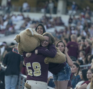student hugging bobcat mascot