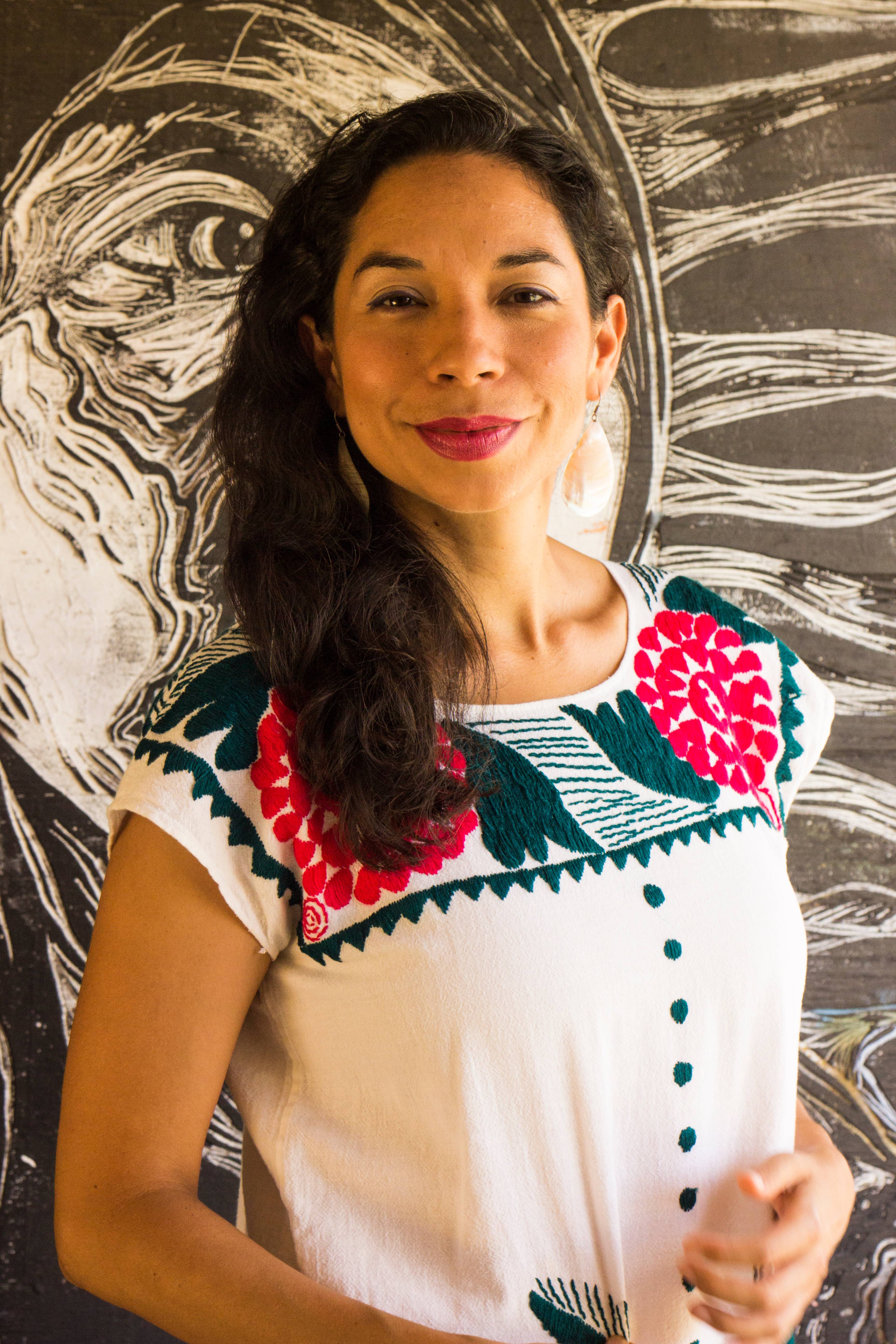 Xelena Gonzalez wearing a white dress with pink flowers and green trim