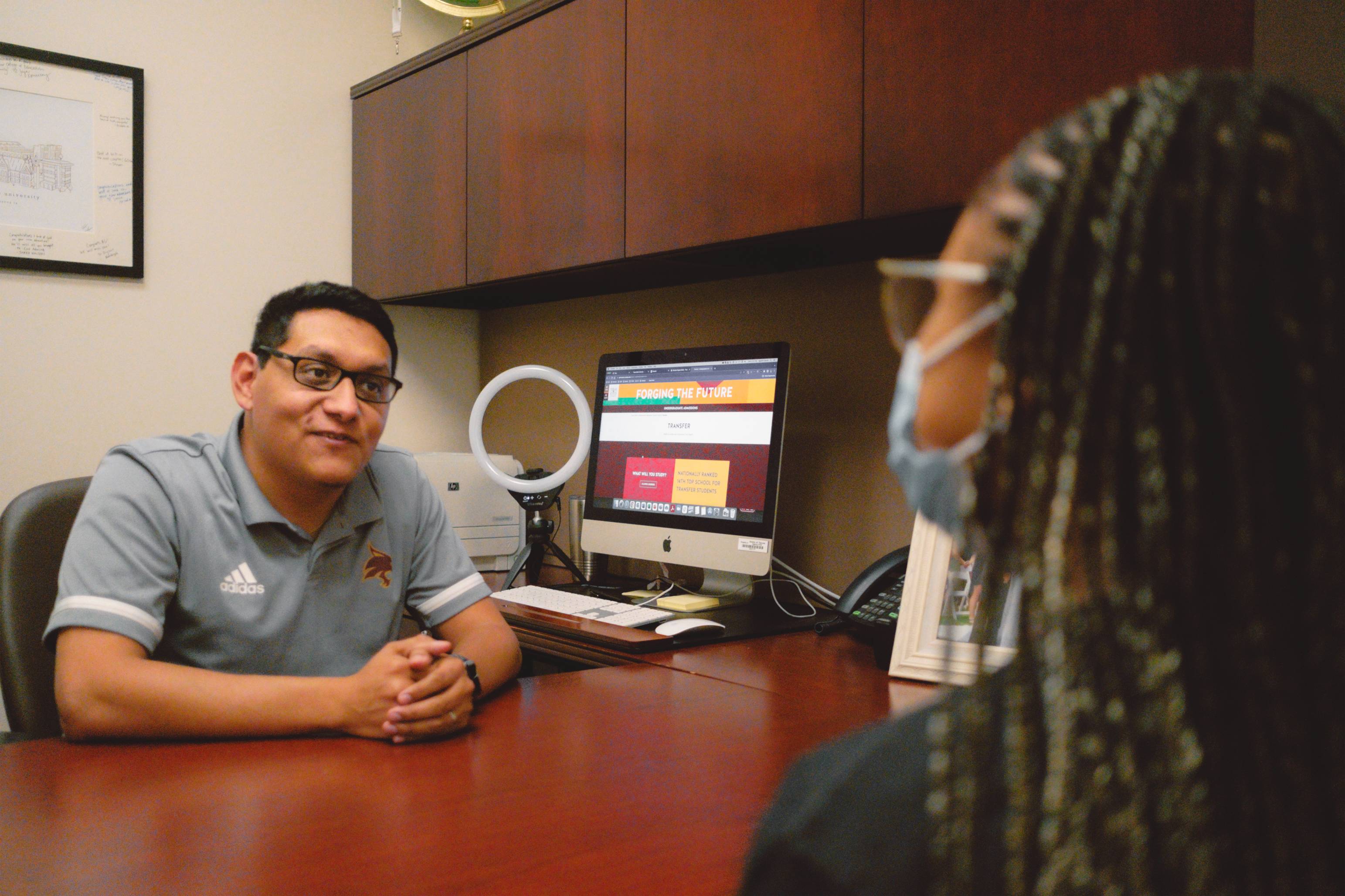 a transfer navigator meeting with a student. the computer screen has the transfer admissions page open.