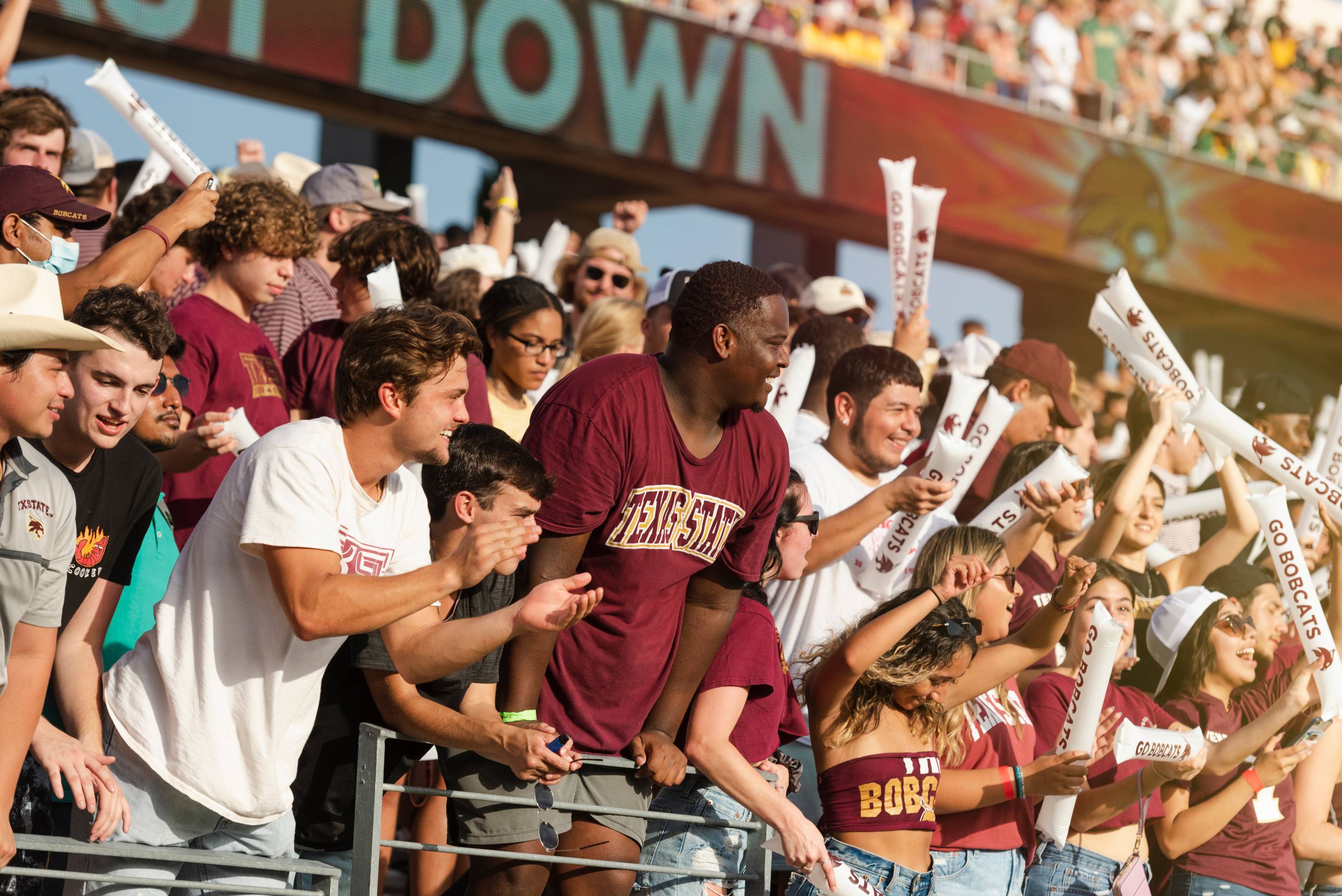 a crowd cheers at a TXST football game