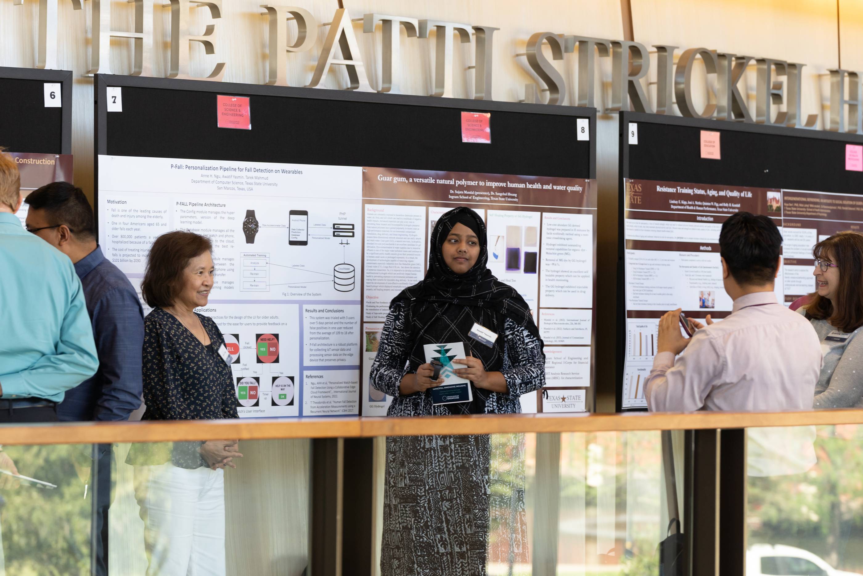 A view of a balcony from inside the Showcase venue. On the balconies, health research posters are displayed and attendees are walking around viewing them. 