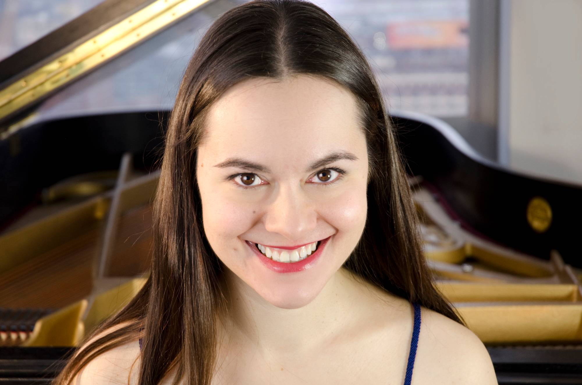 Headshot of Daria Rabotkina in front of an open grand piano