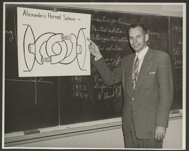 Photograph of R.H. Bing in a classroom standing in front of a chalkboard