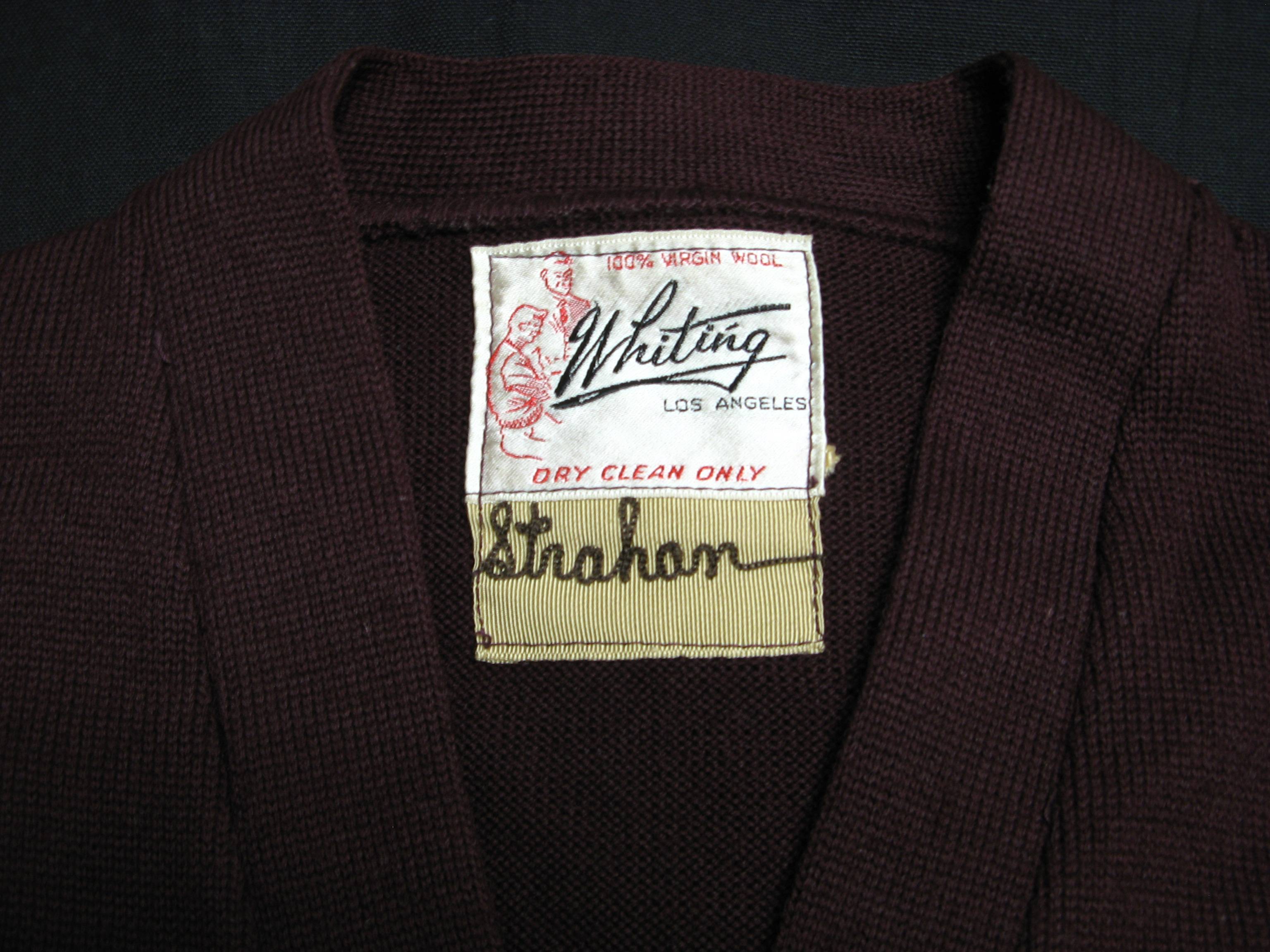 Photograph of the inside label of the sweater with the name "Strahan" sewn inside.