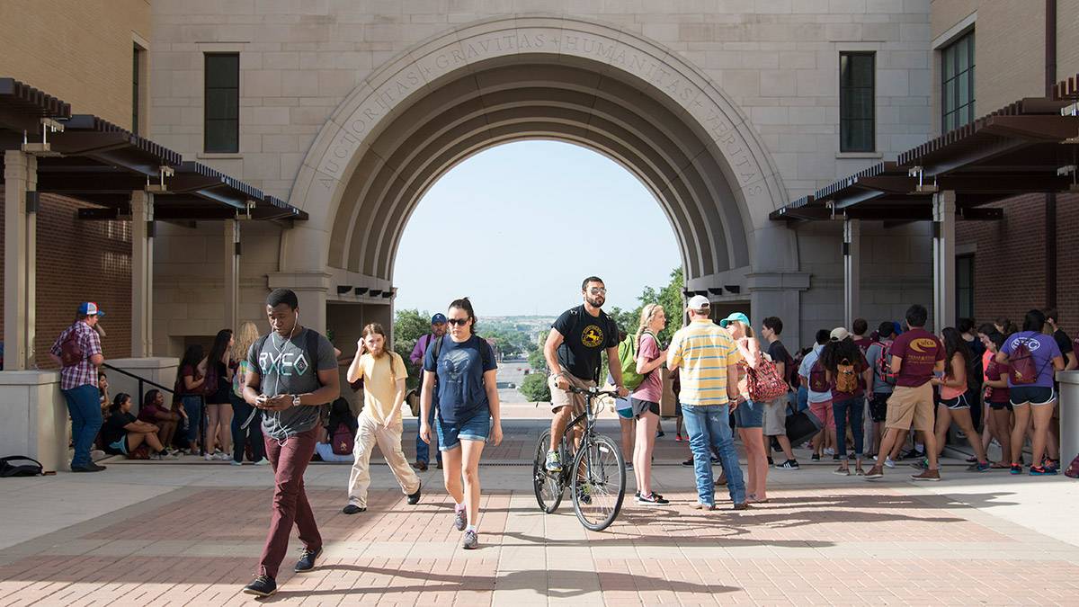 Student walking near the UAC arch.
