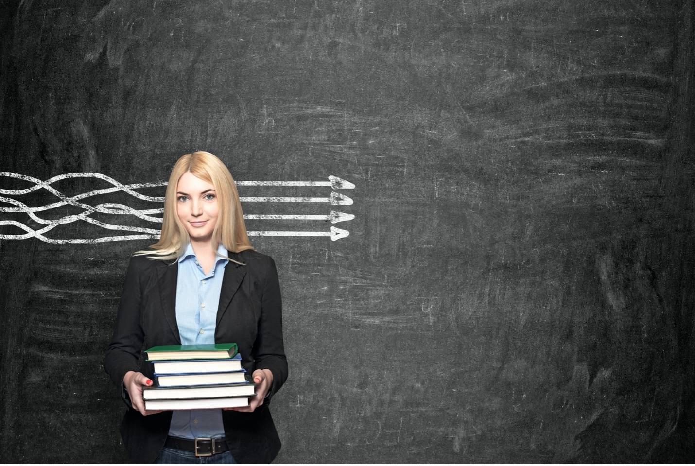 A woman standing in front of a chalkboard with parallel lines drawn behind her