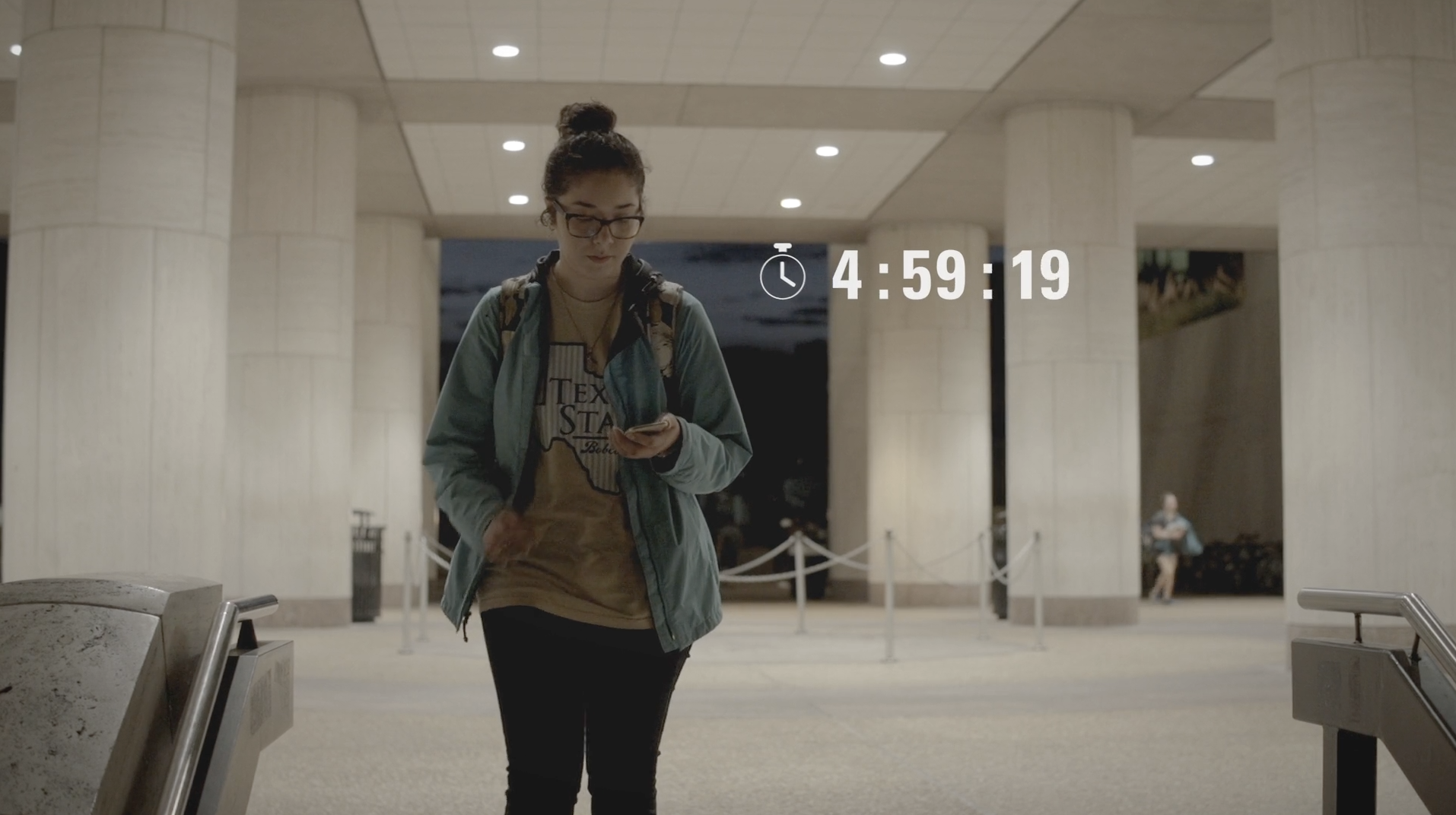 a student demonstrates how to use the Bobcat Guardian App as she walks across campus at night