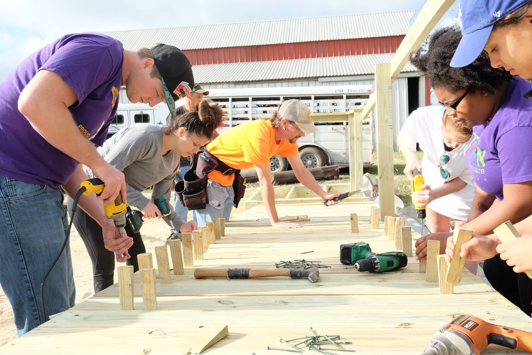 Student volunteers drilling on wood at a building project