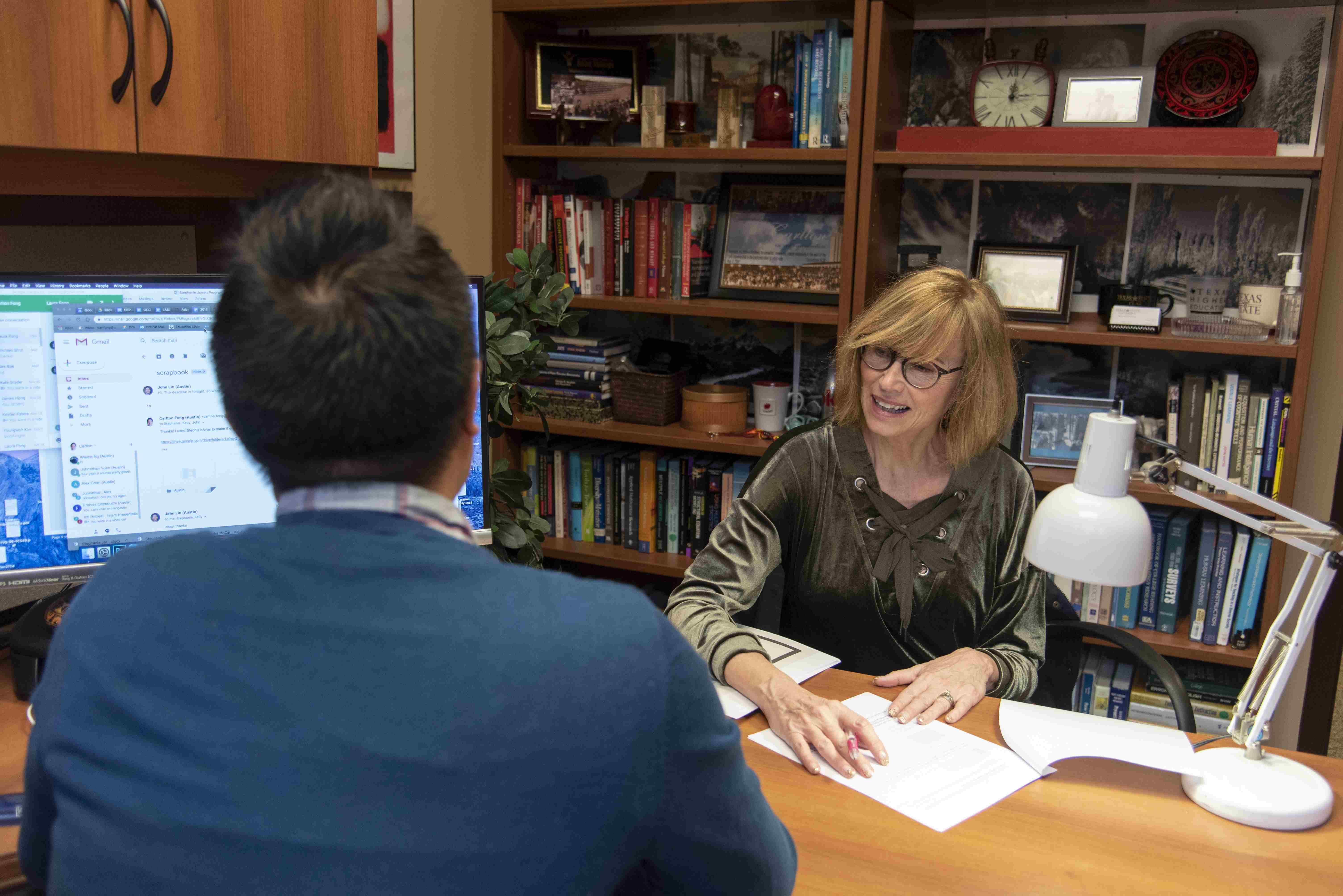 an advisor sits across her desk from a student