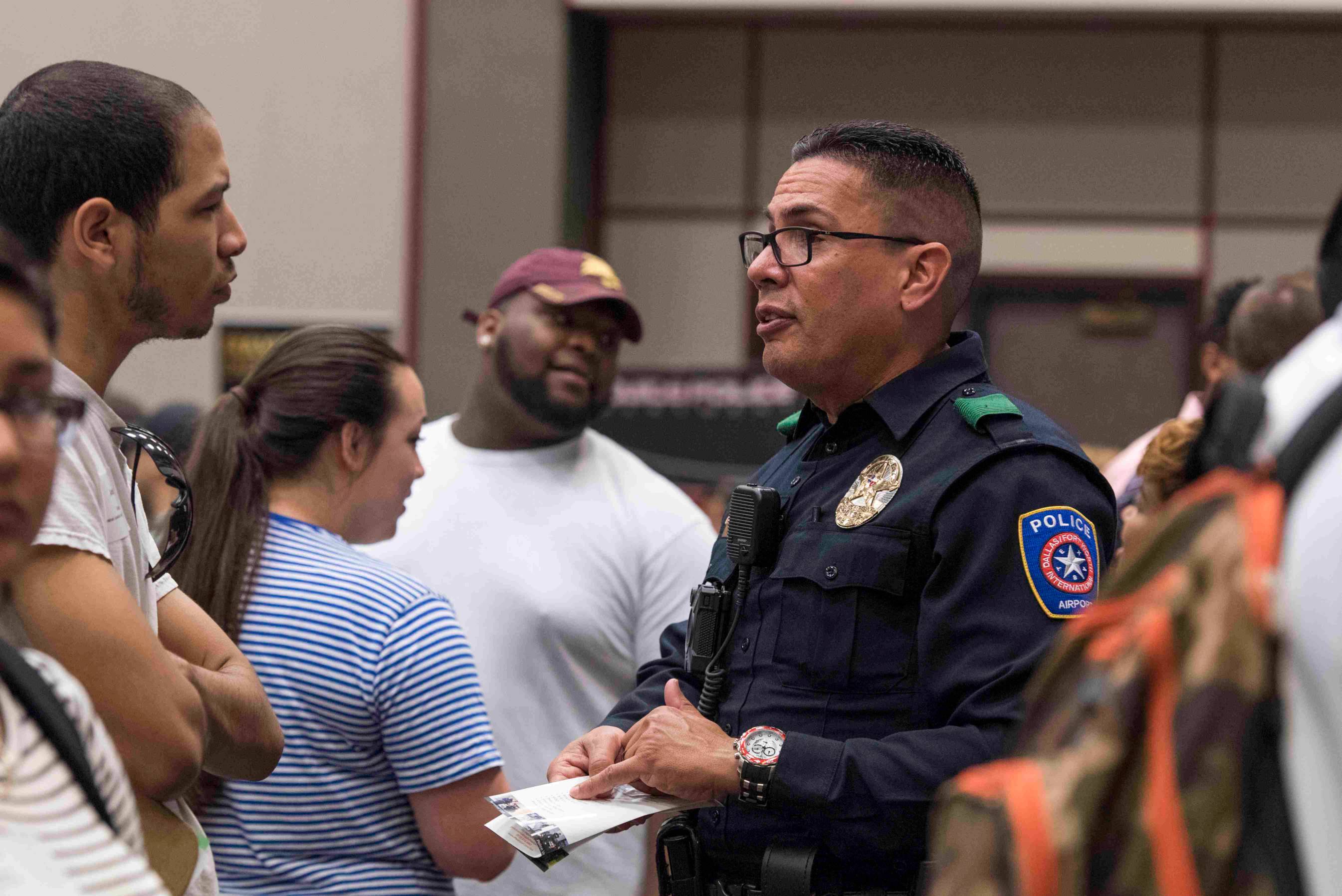a police officer stands talking to a student during a career fair