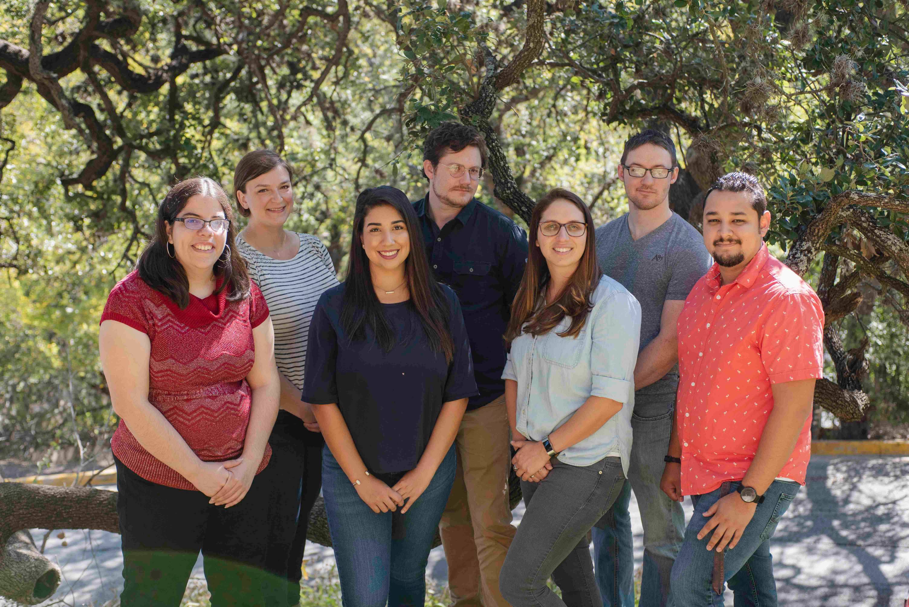seven PHD students pose outside for a group photo