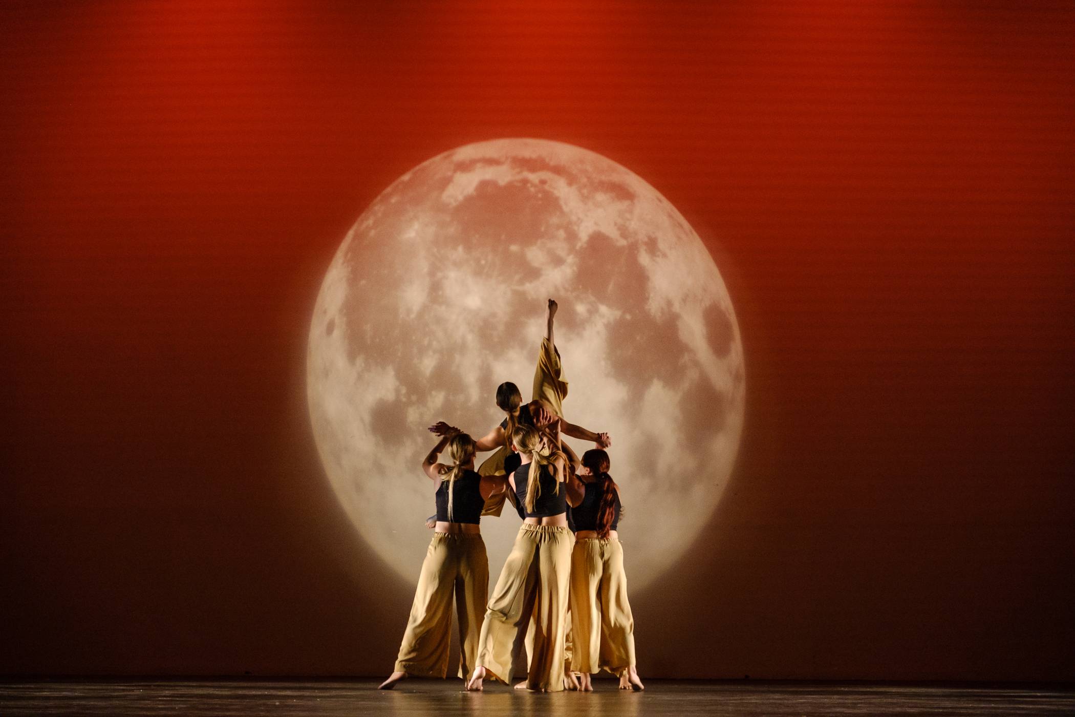 Texas State Dancers in front of a moon.