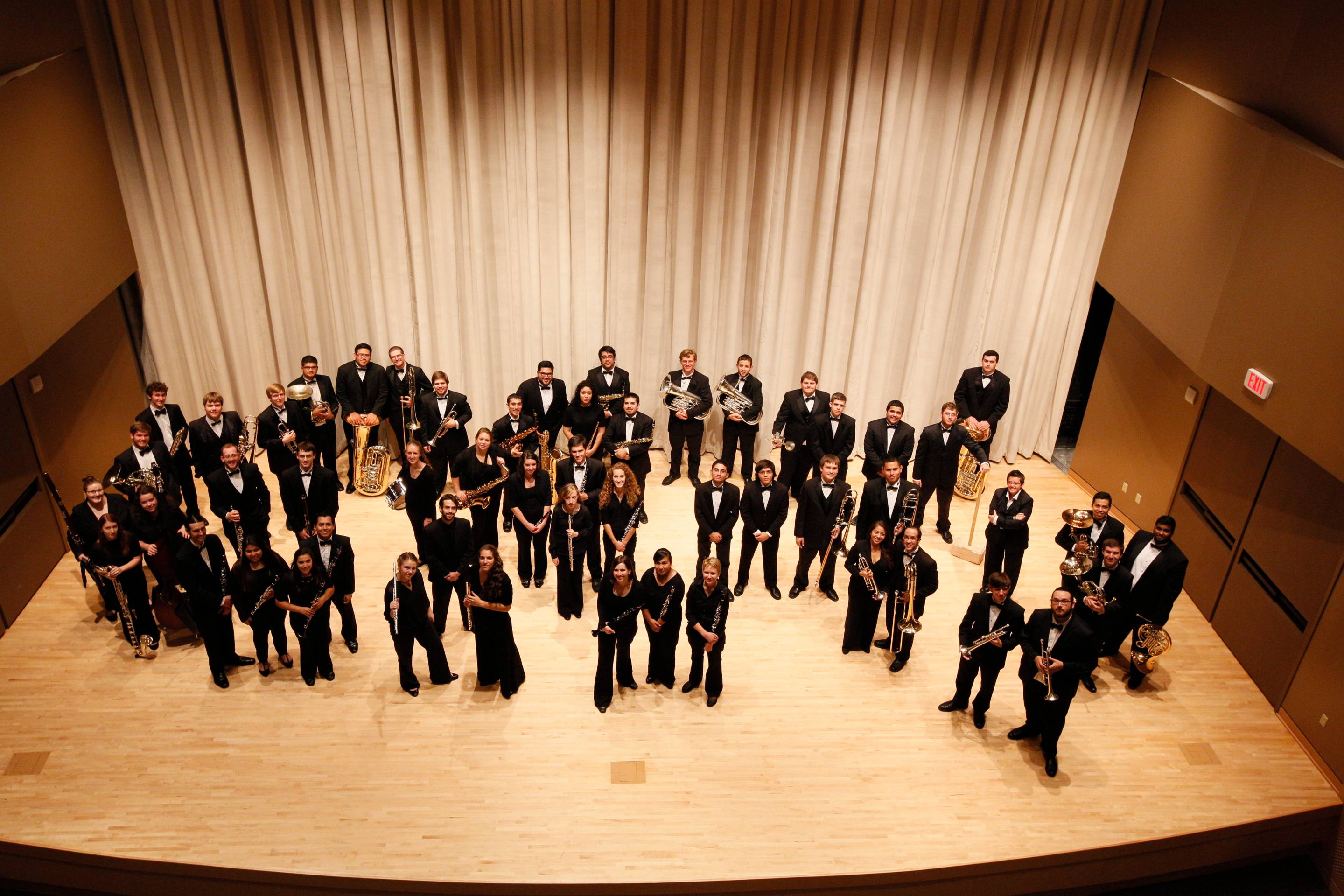 Image of band members on stage looking. at camera