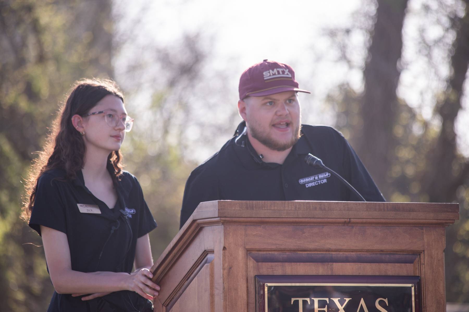 Student co-directors on stage in front of podium