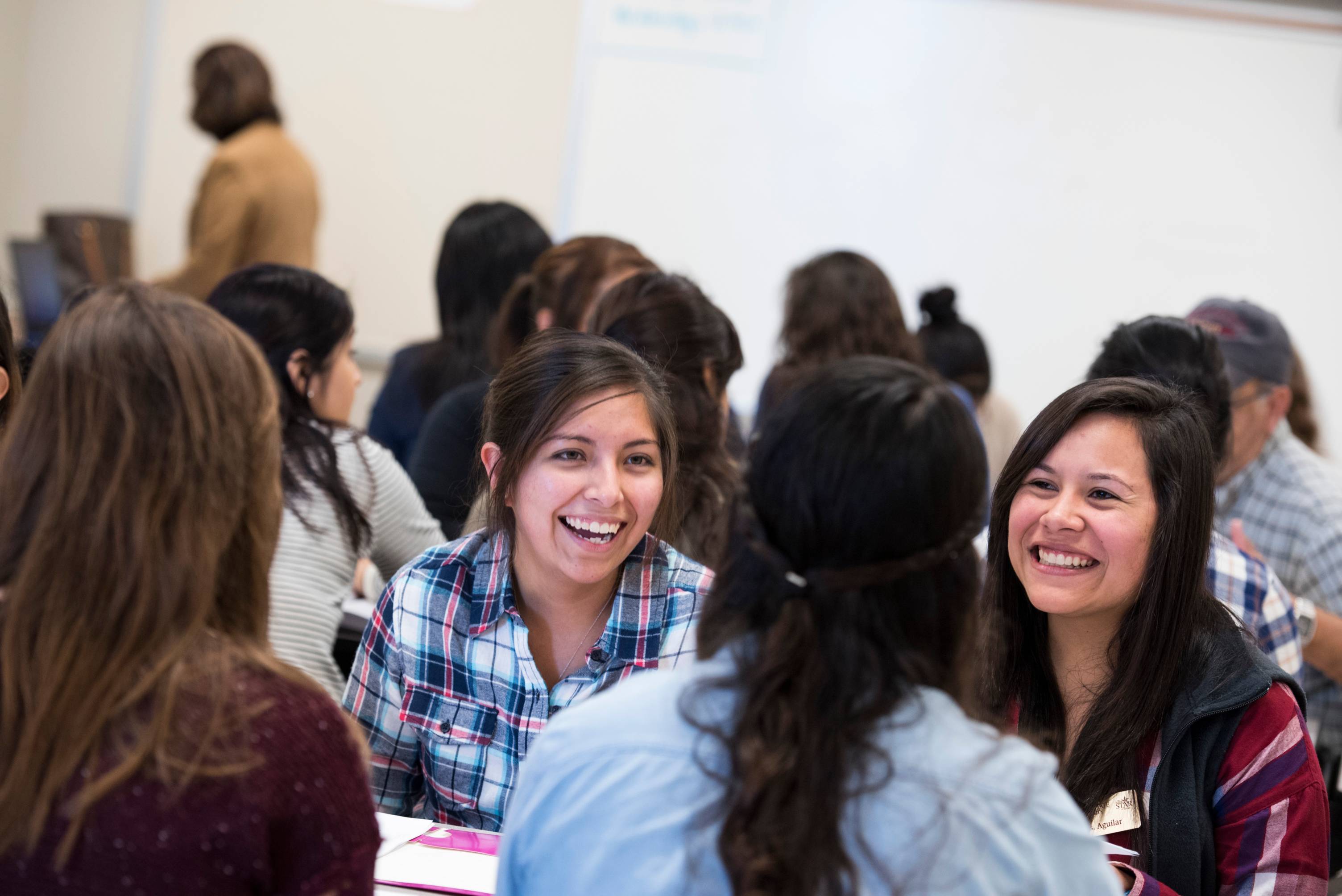 student sitting at a table smiling