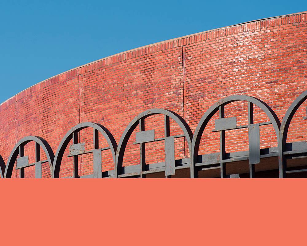 Rounded edge of our Theatre Building with stripe of peach color