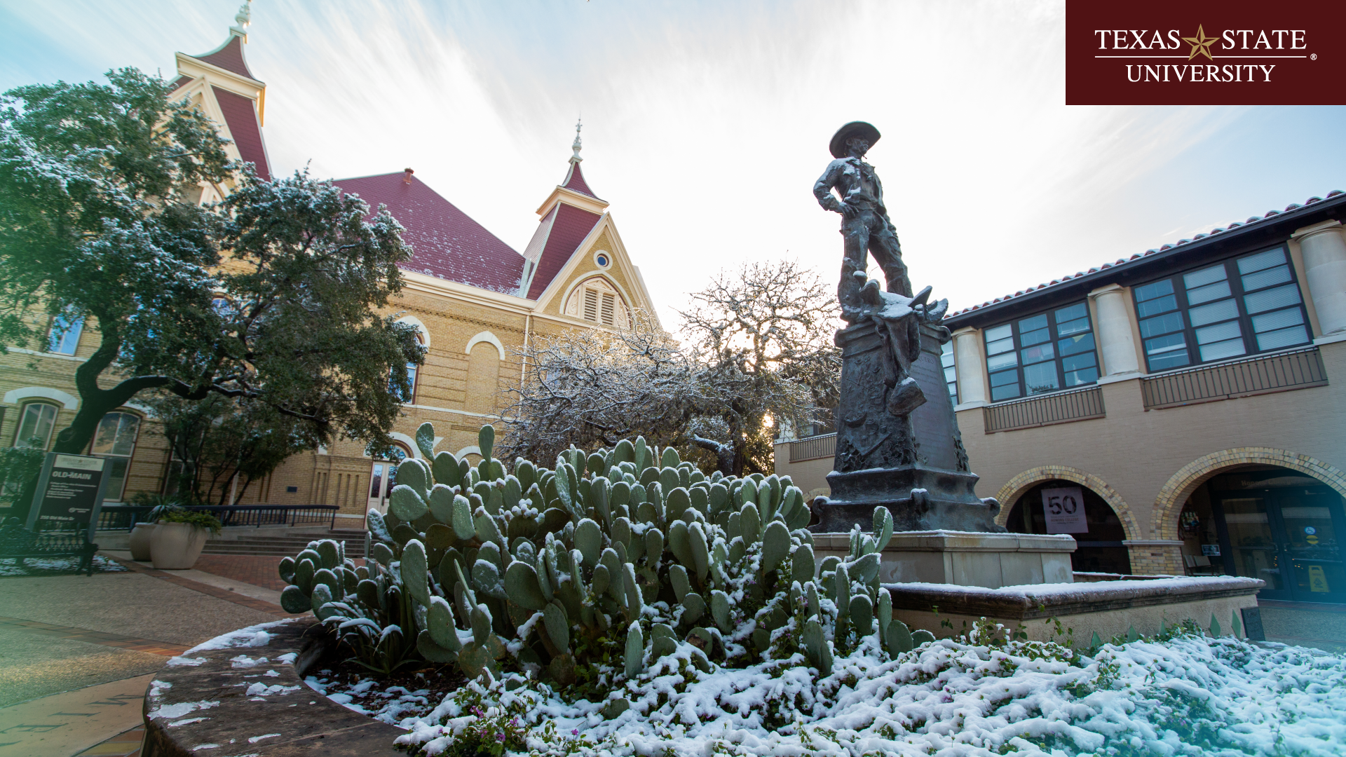 Snowy Old Main with Vaquero statue