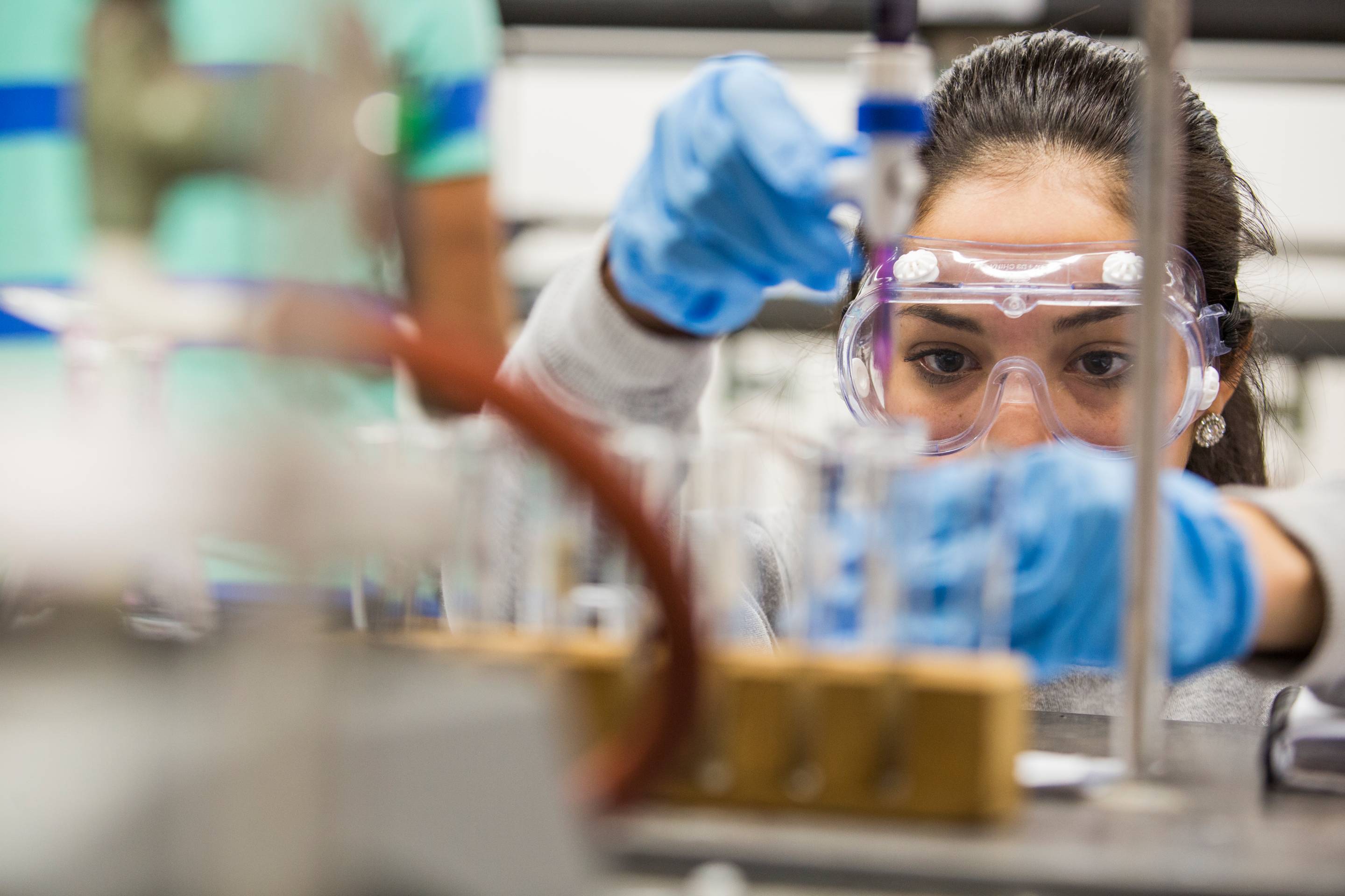 Student uses a pipet to carefully measure out a chemical substance in a lab