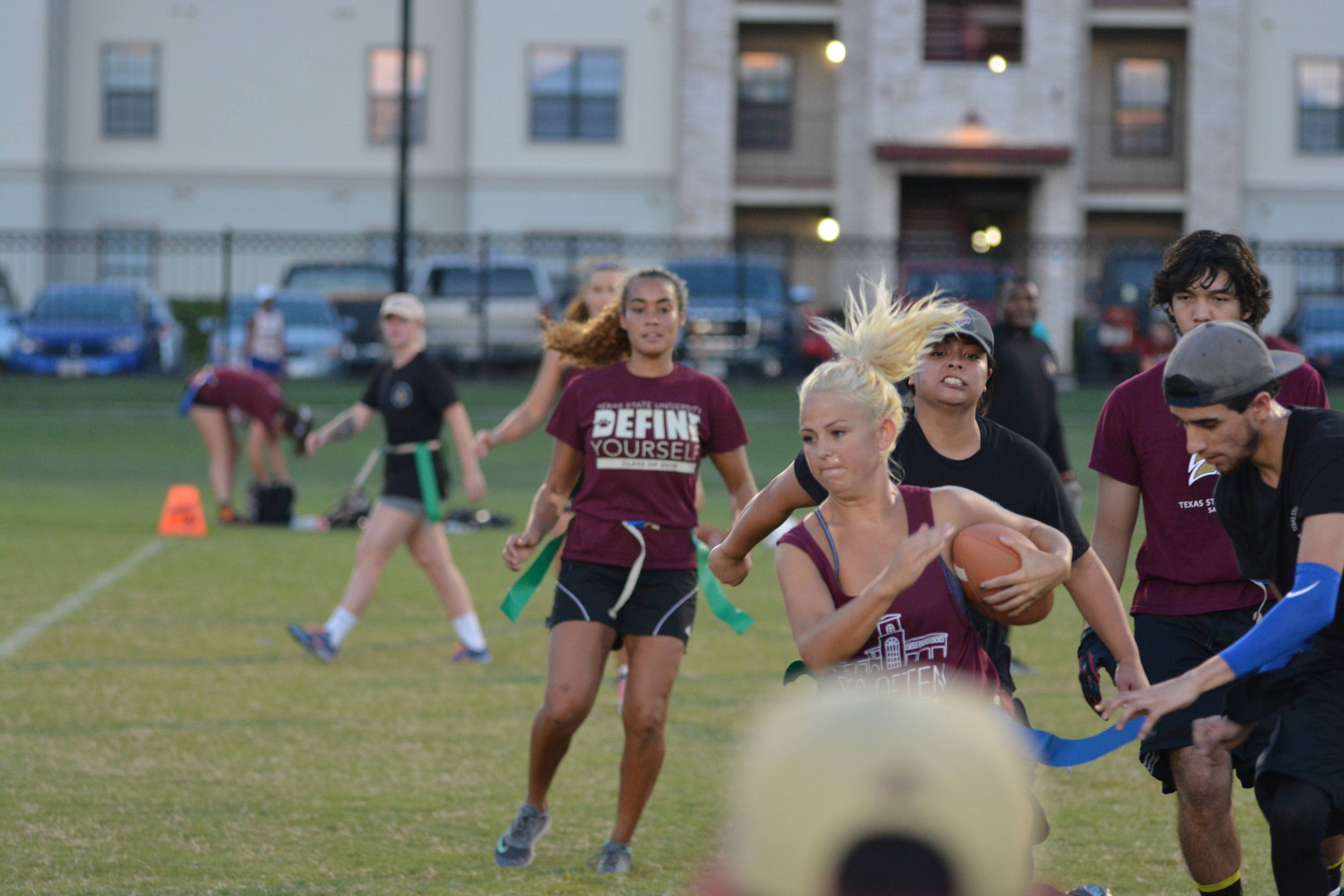 Flag football game; Girl running with a ball