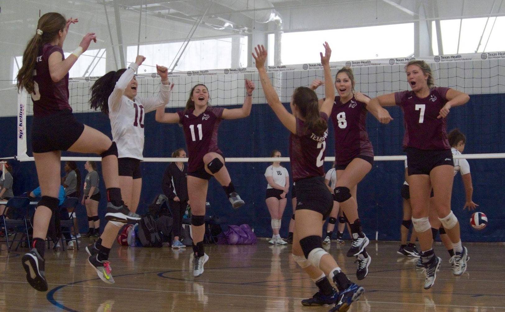 Women's Volleyball players all jumping celebrating a point