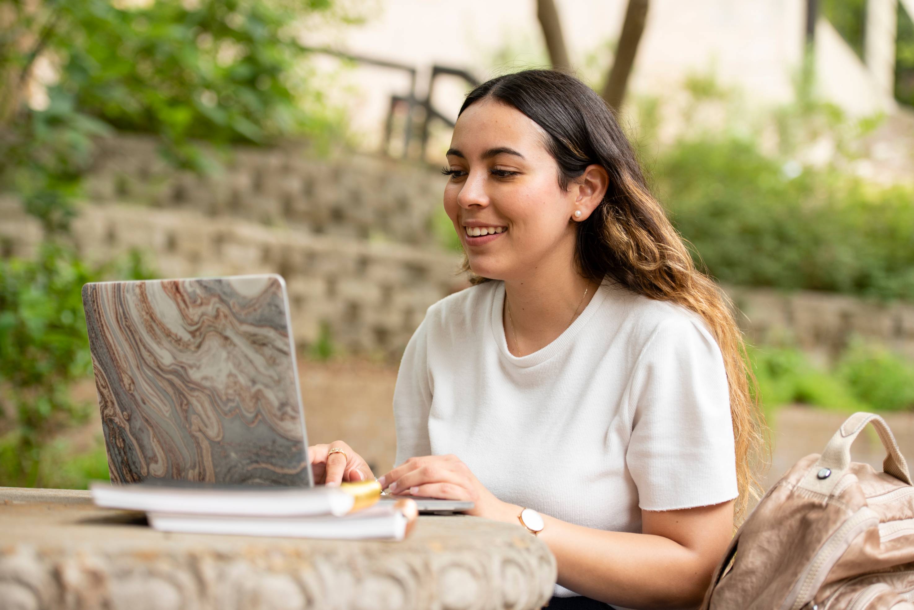 Texas State student smiling on laptop
