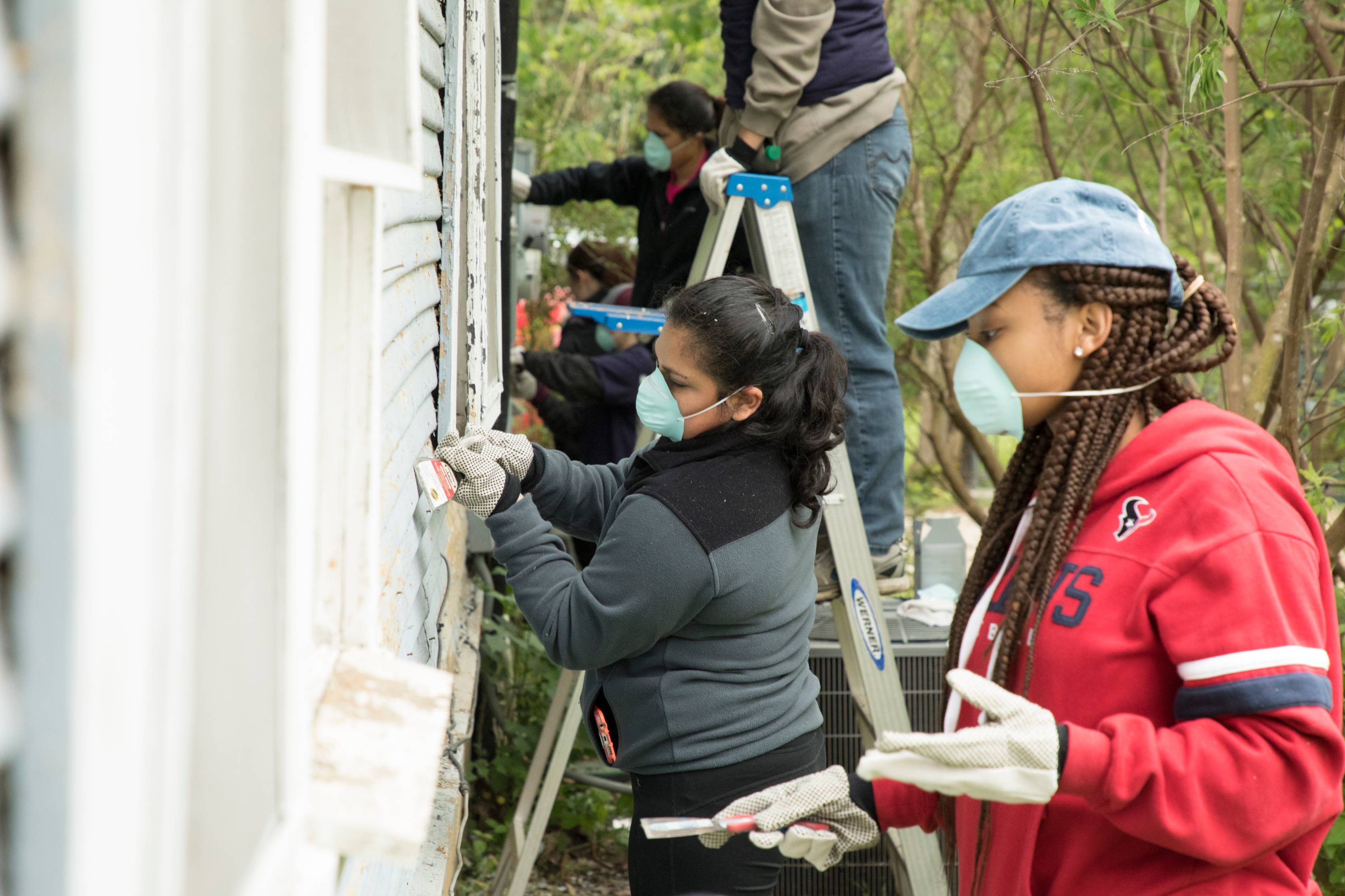 students painting a house