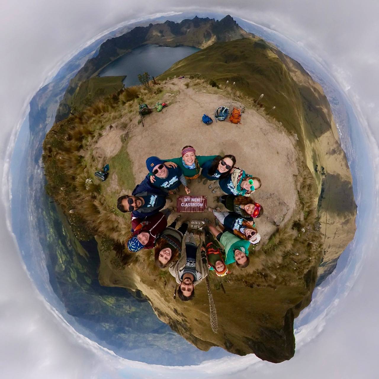 Earth vision of students holding each other in circle with banner 'New classroom' in the middle.