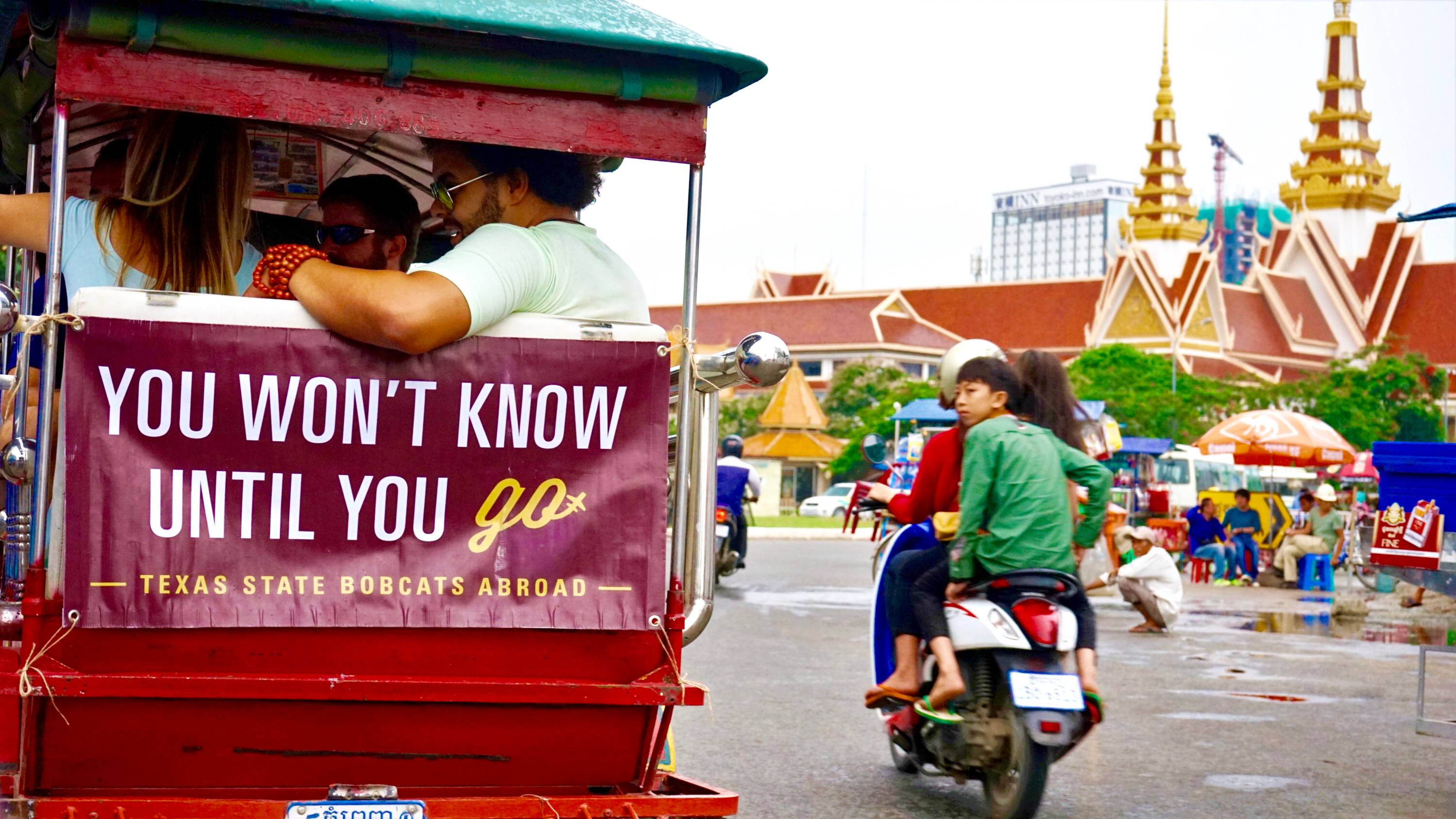 Students in India on Tuktuk with banner 'My new classroom' attached in the back