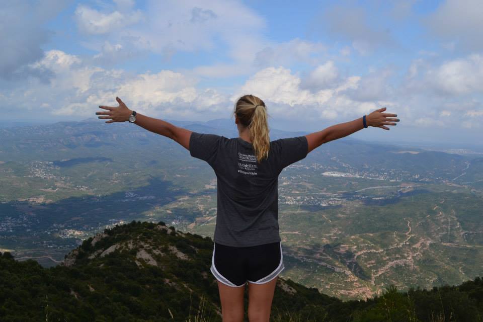 Student facing a valley from top of the mountain