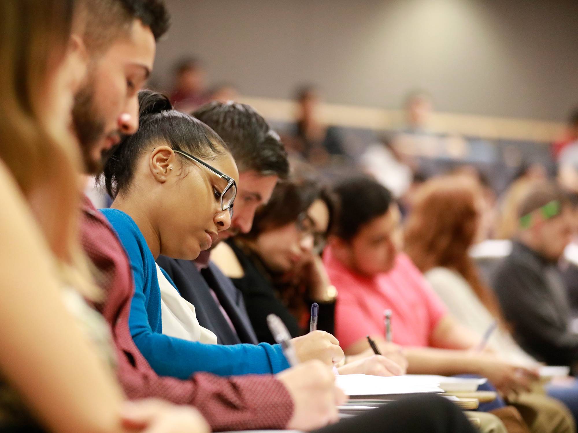 Students taking notes in a lecture hall