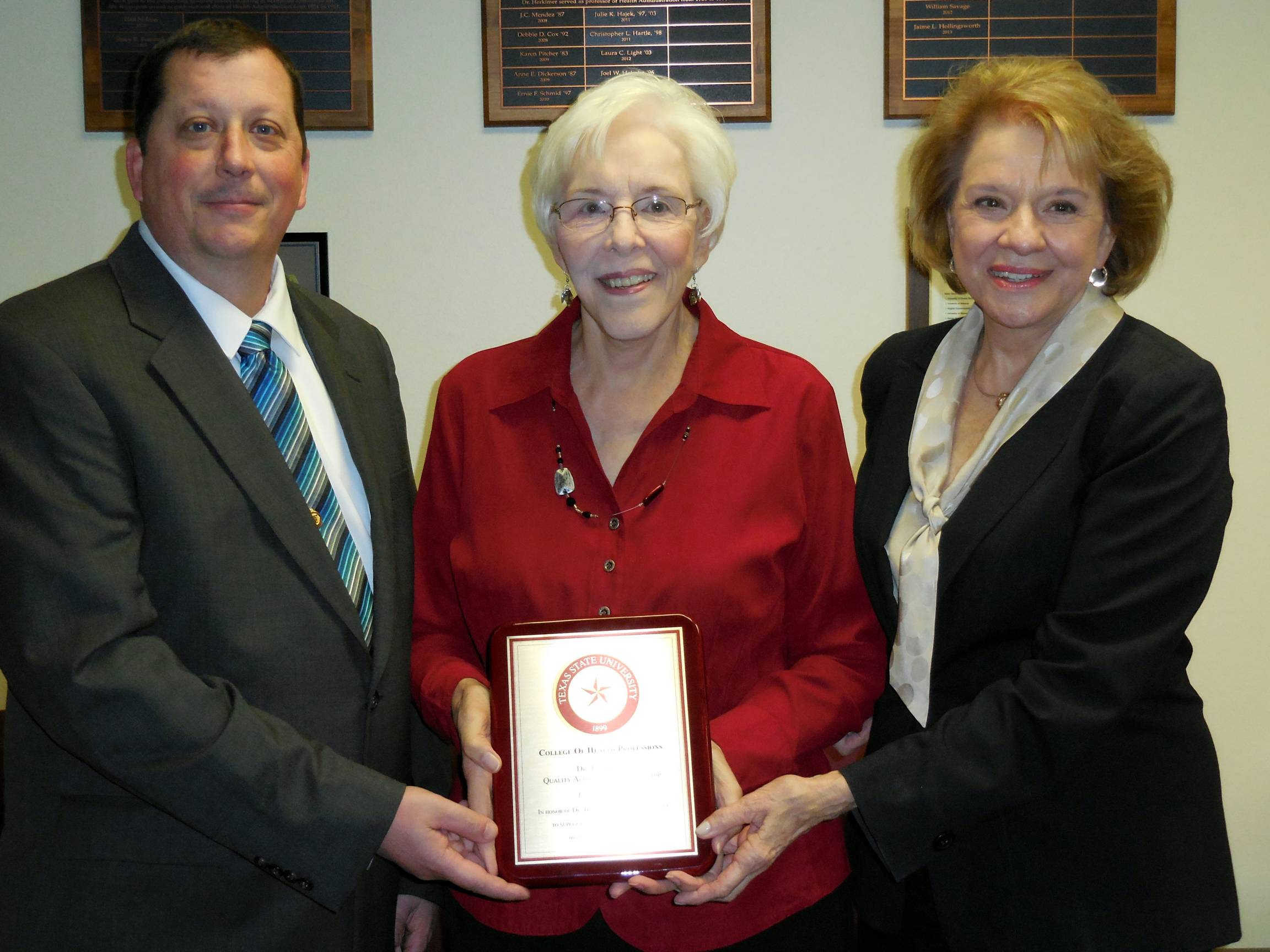 Dr. Boone receiving a plaque from Dean Ruth Welborn and Dr. Matthew Brooks