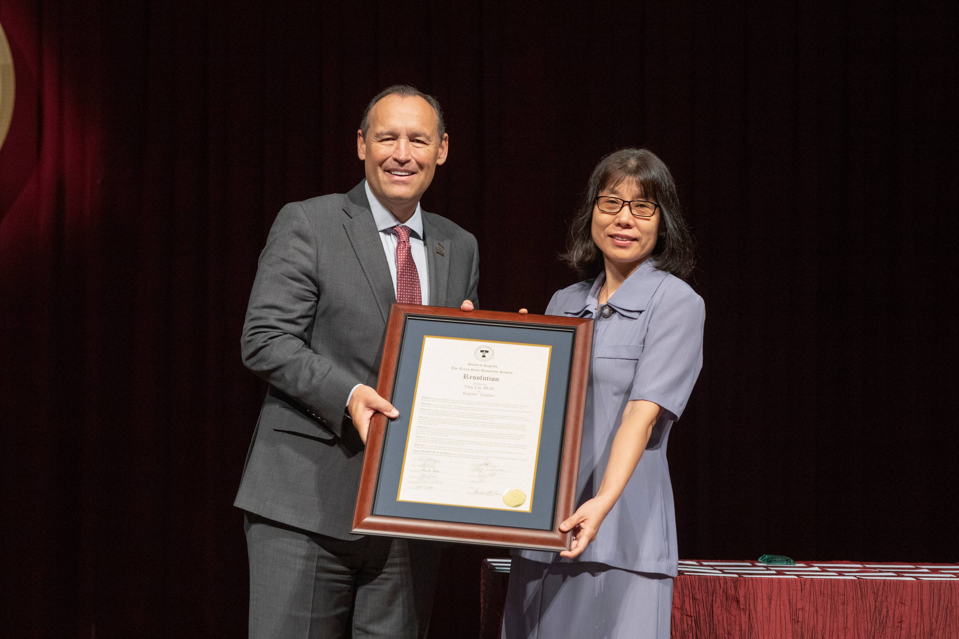Dr. Liu receiving award from Dr. Damphousse