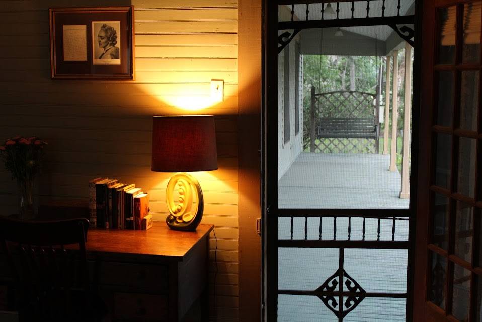A warm lamp lights the cozy room outside of the porch of the Katherine Anne Porter Literary Center