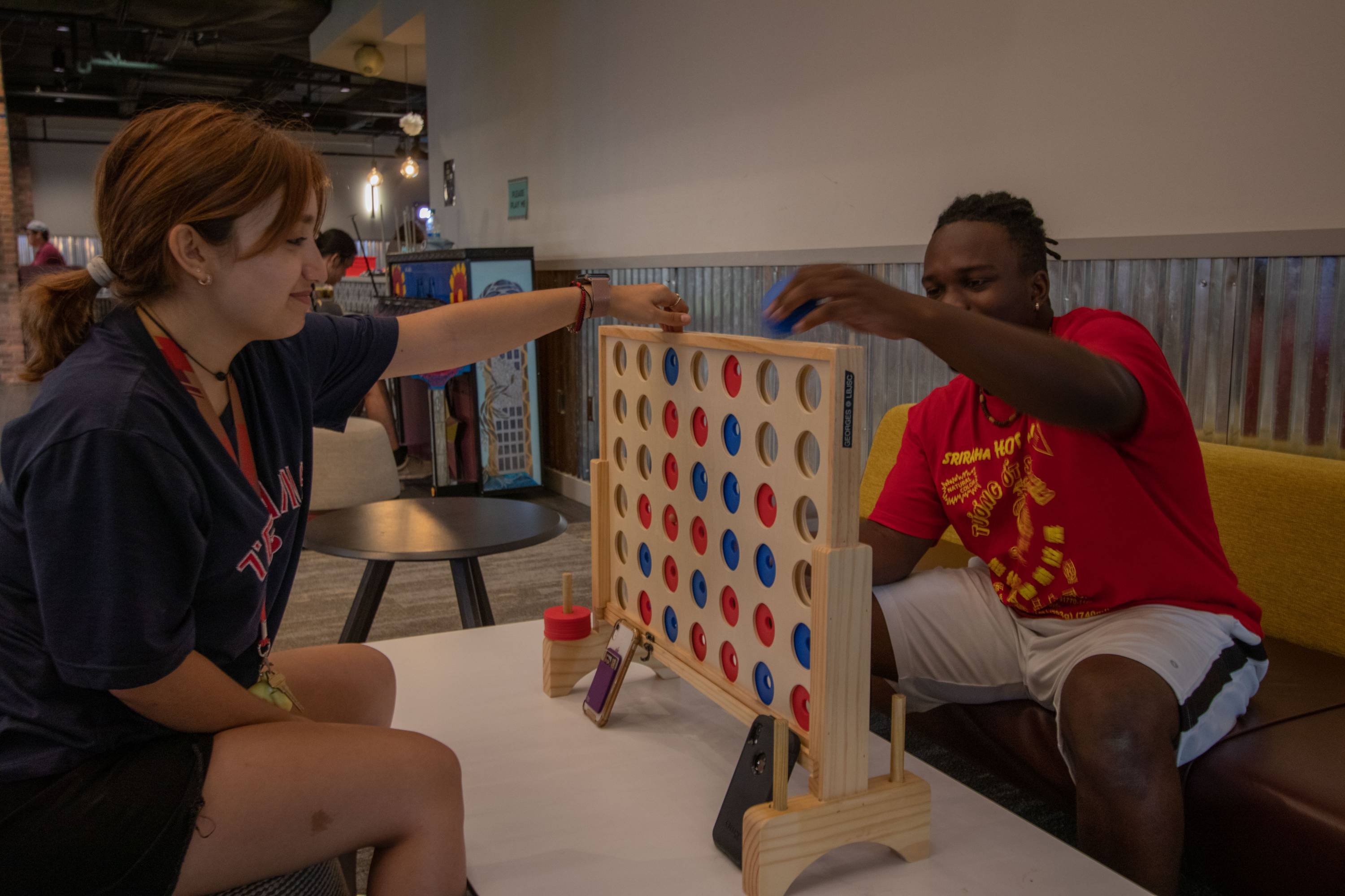 two students playing connect four game 