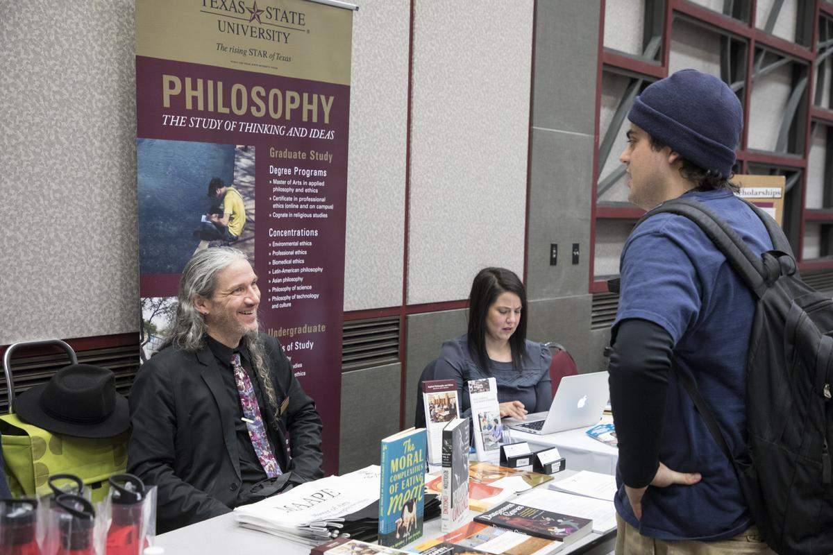 photo of a student speaking with a professor at a fair