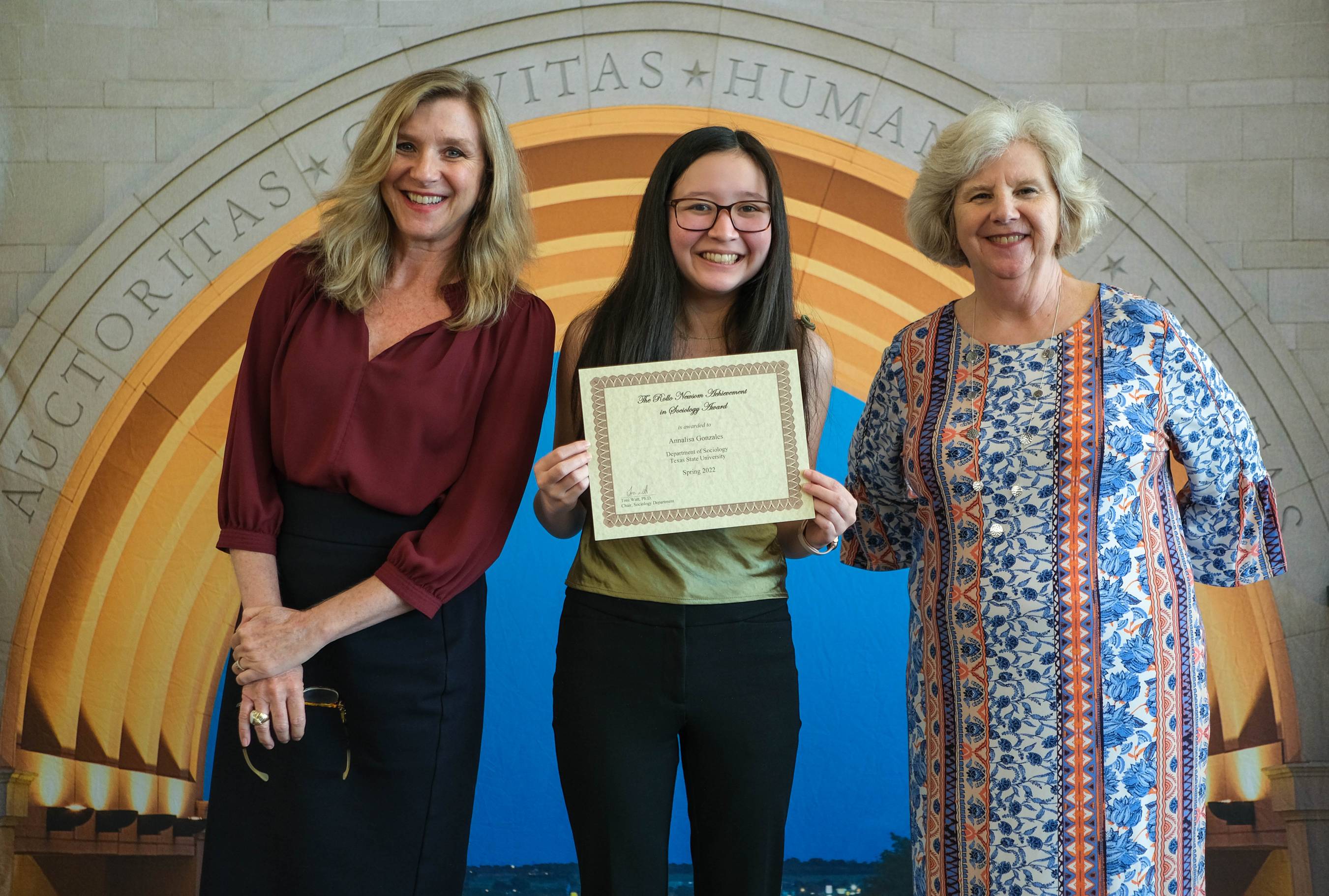 Student with deans and certificate at award ceremony
