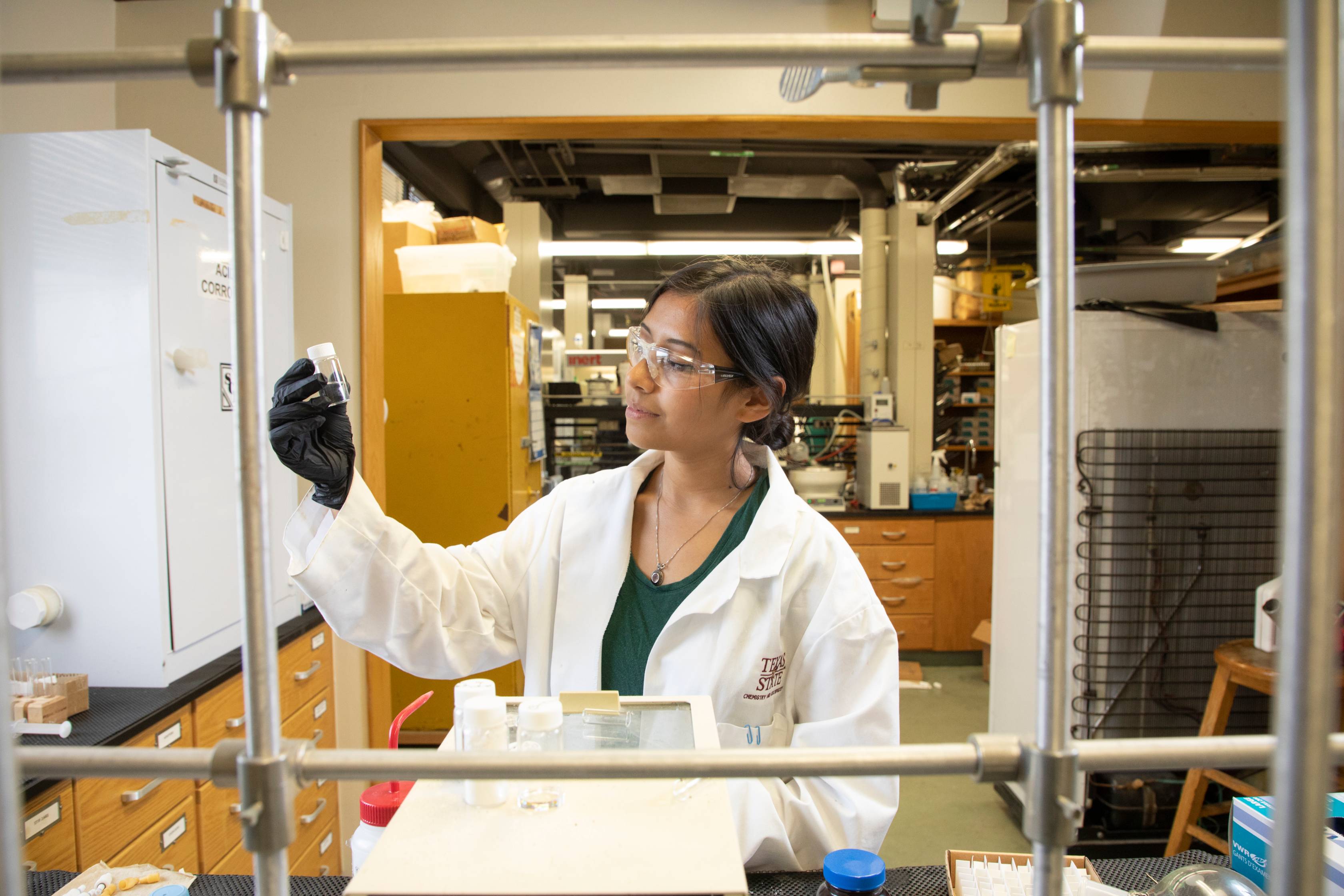 Student uses a pipet to dispense liquid into a container in lab