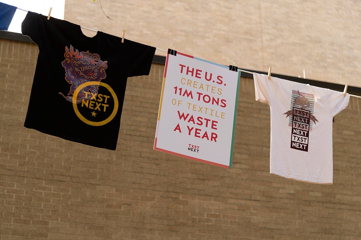 shirts and sign hanging from a clothesline
