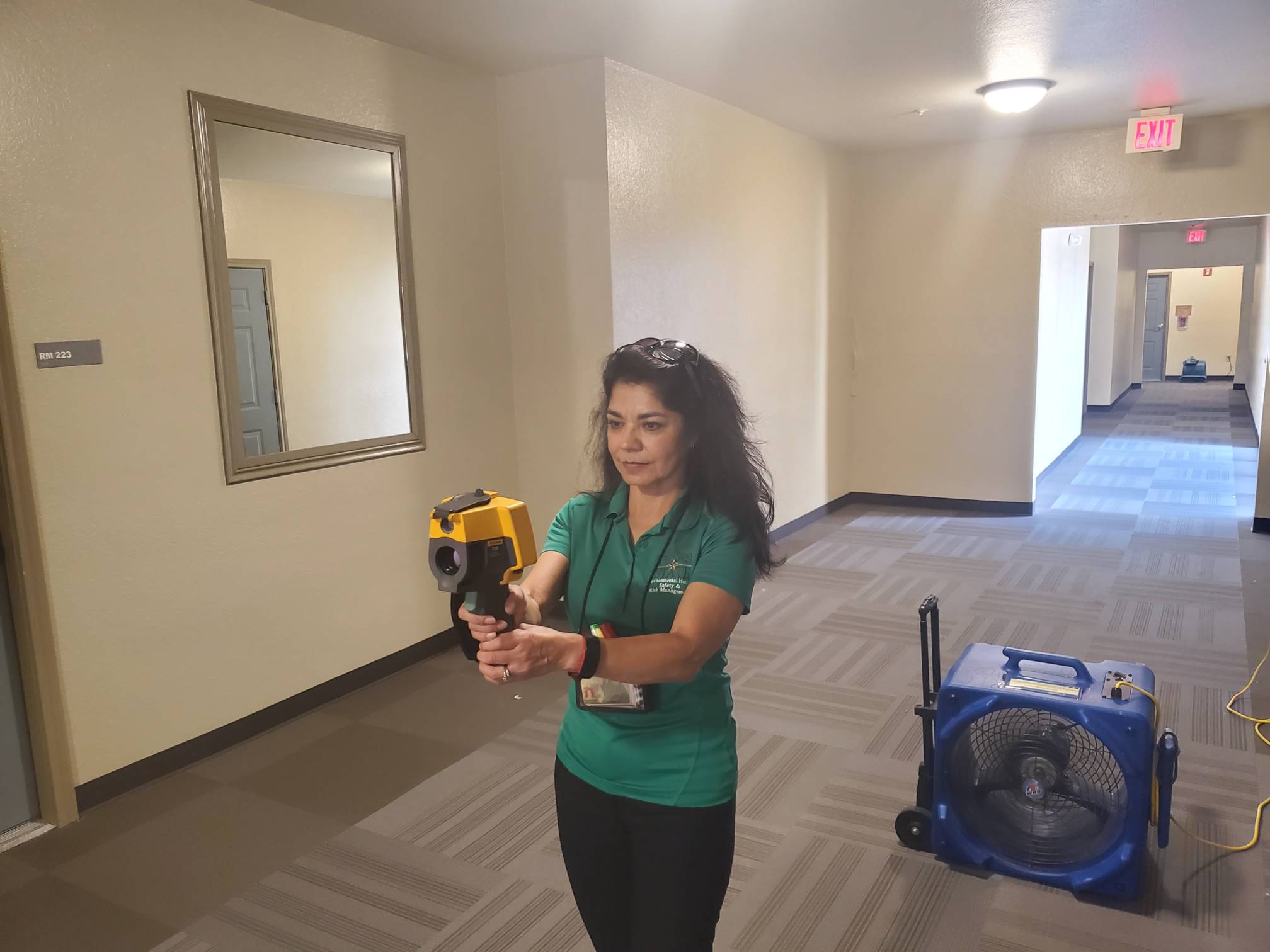 EHS Specialist uses an air monitoring device to asses the air quality of a corridor in a TXST building. 