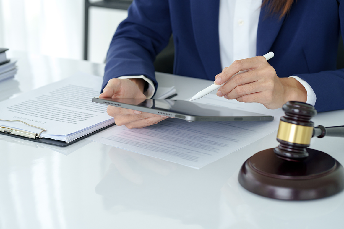 A man writing with a gavel on his desk