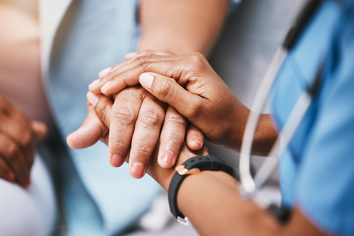 A physical therapy aid holding a patient's hands. 