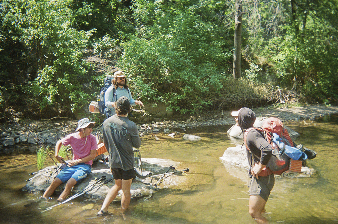 hikers wading in creek