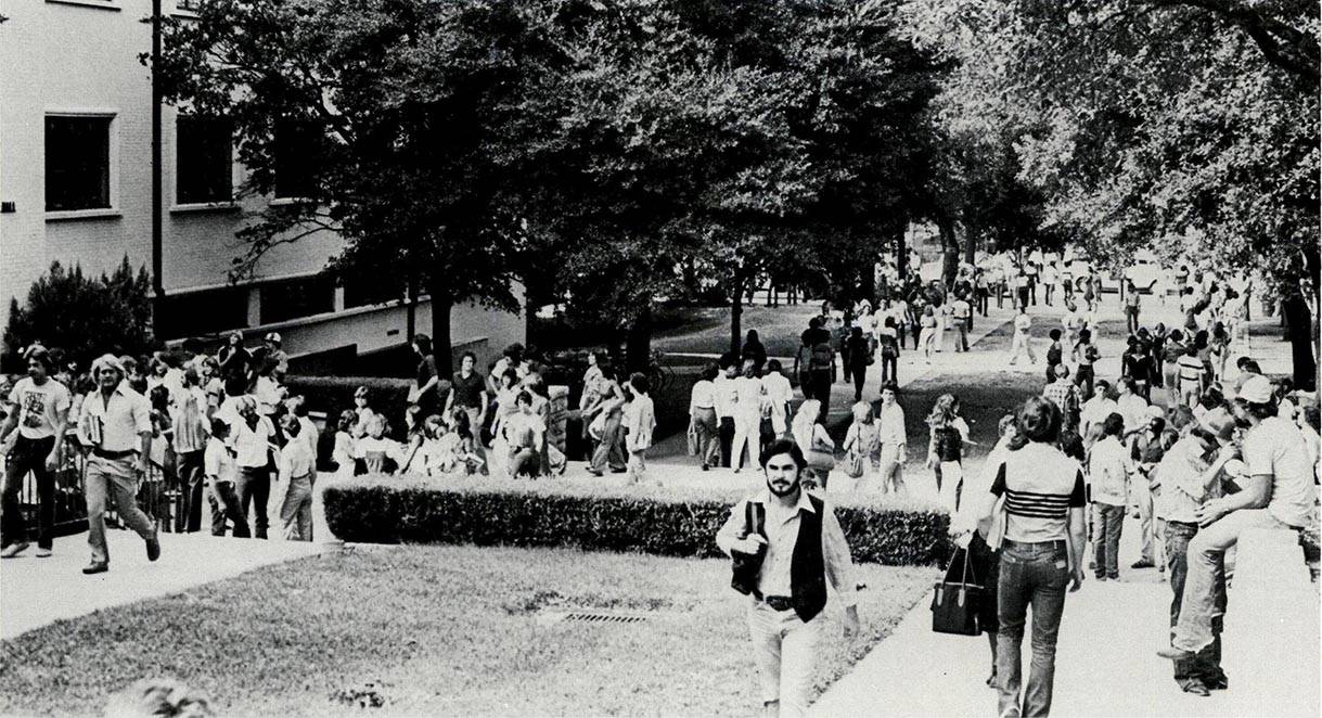 black and white photo of people walking in txst's quad