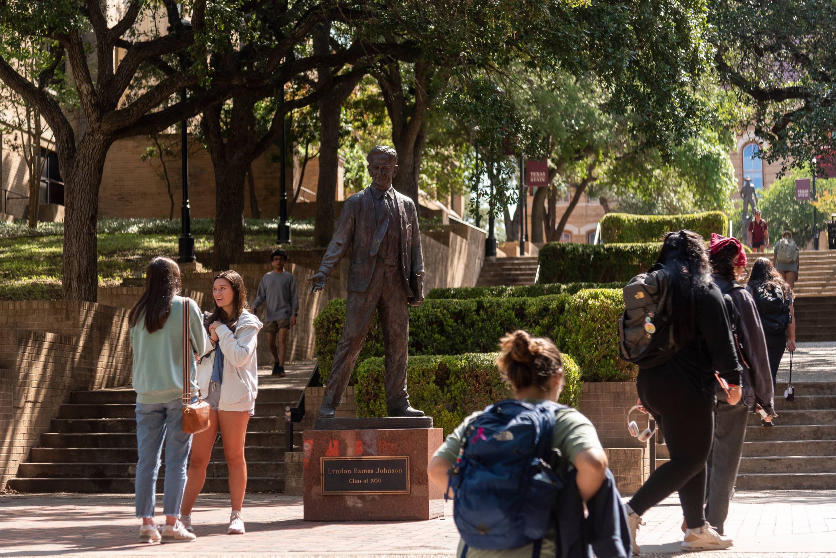 Student walking by LBJ statue