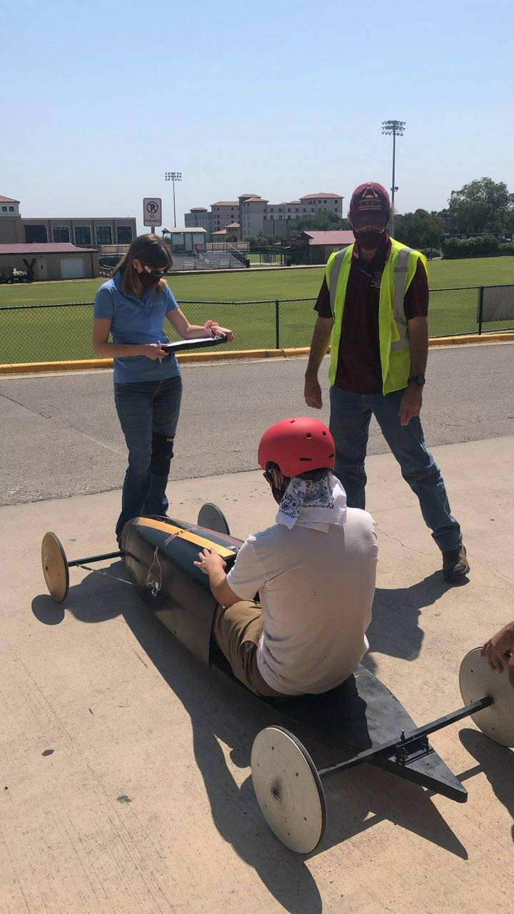 Two EHS Specialists assist with inspections of Derby cars in preparation of the homecoming race. 