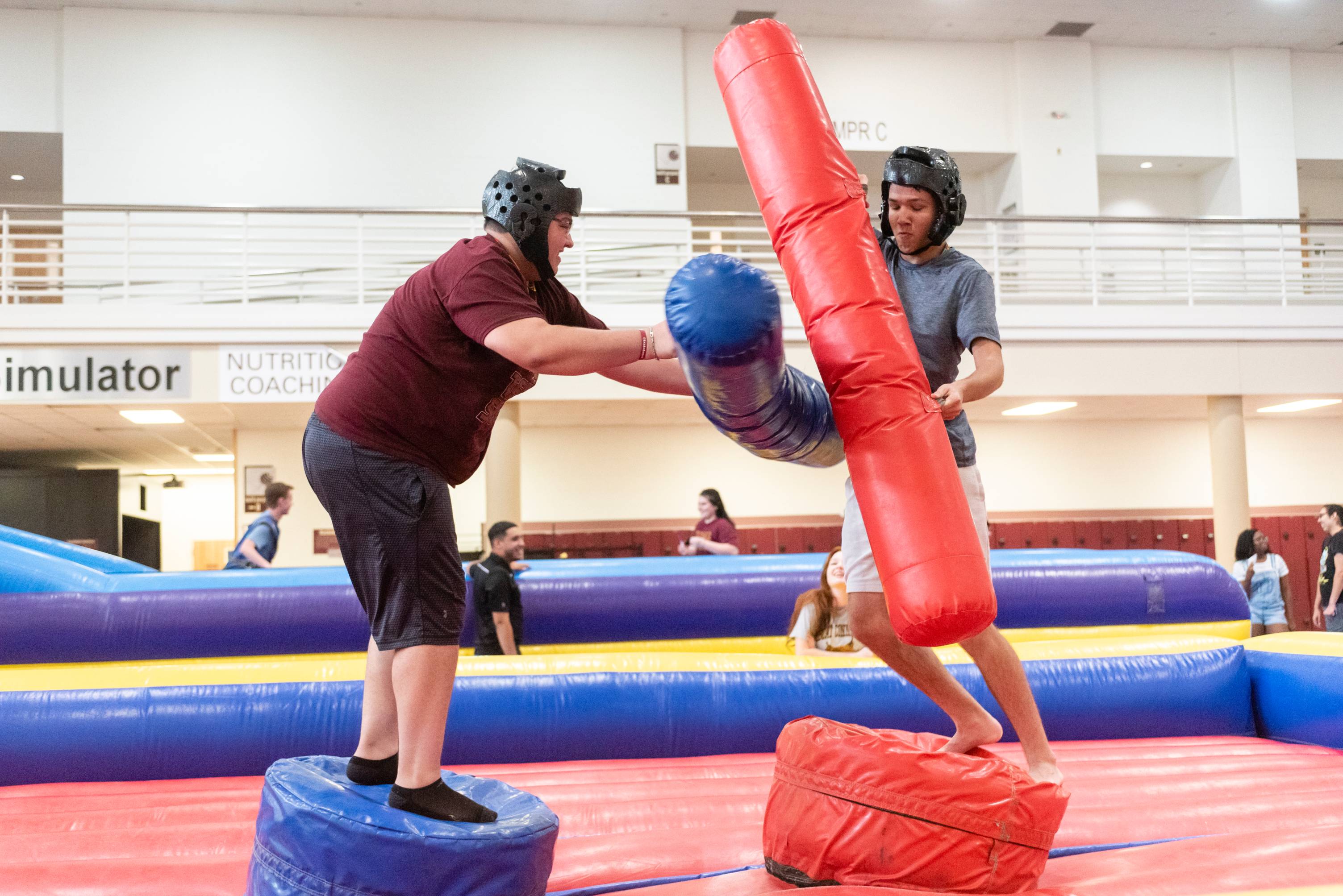 Two students battle each other on a blow up jousting activity. 