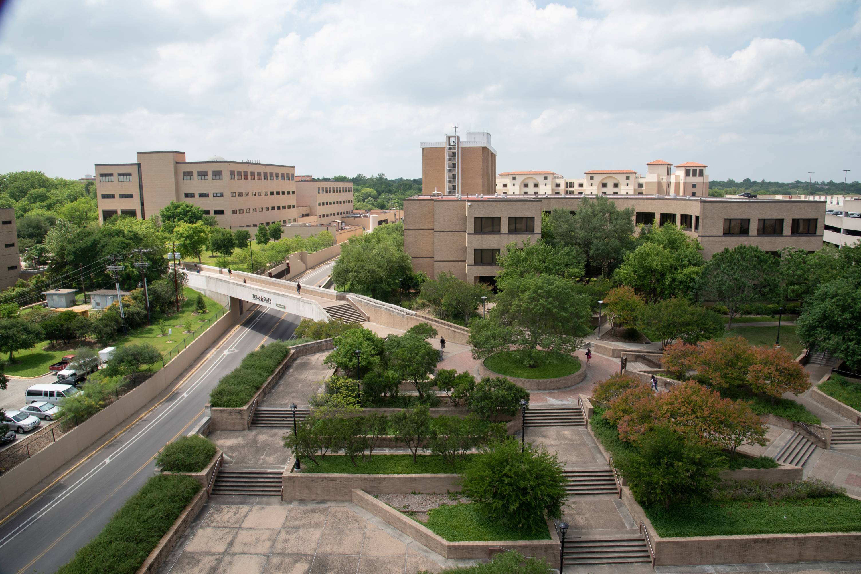Aerial view from McCoy Hall of Encino Hall and the greenery and walkways in front of it; to the side is the North Comanche Bridge and the Roy F. Mitte Building